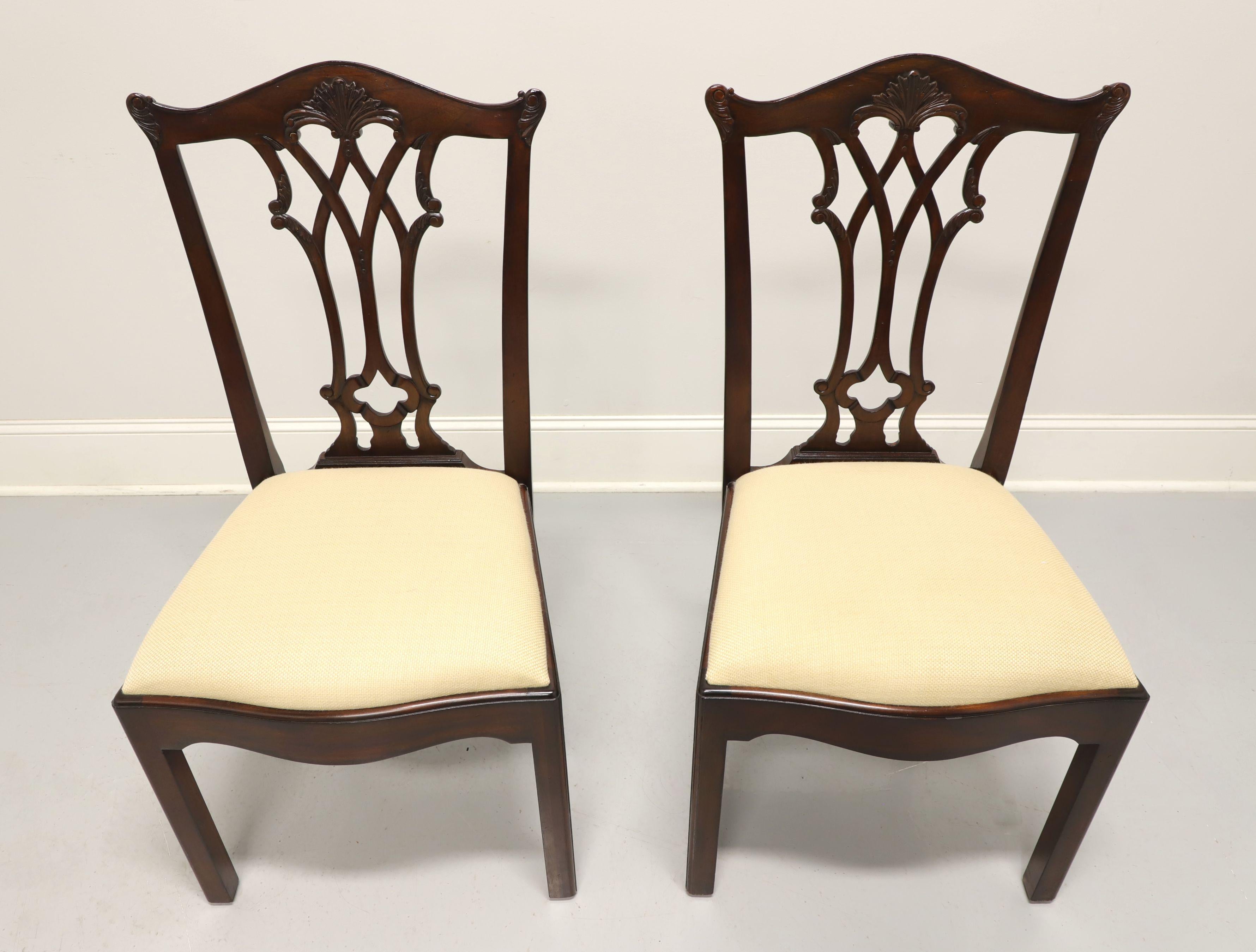 A pair of Chippendale style dining side chairs made for high end furniture dealer, Colony Furniture of Charlotte, North Carolina, USA, under their private label by Maitland Smith, their Connecticut Regency. Solid mahogany with carved crest rail,