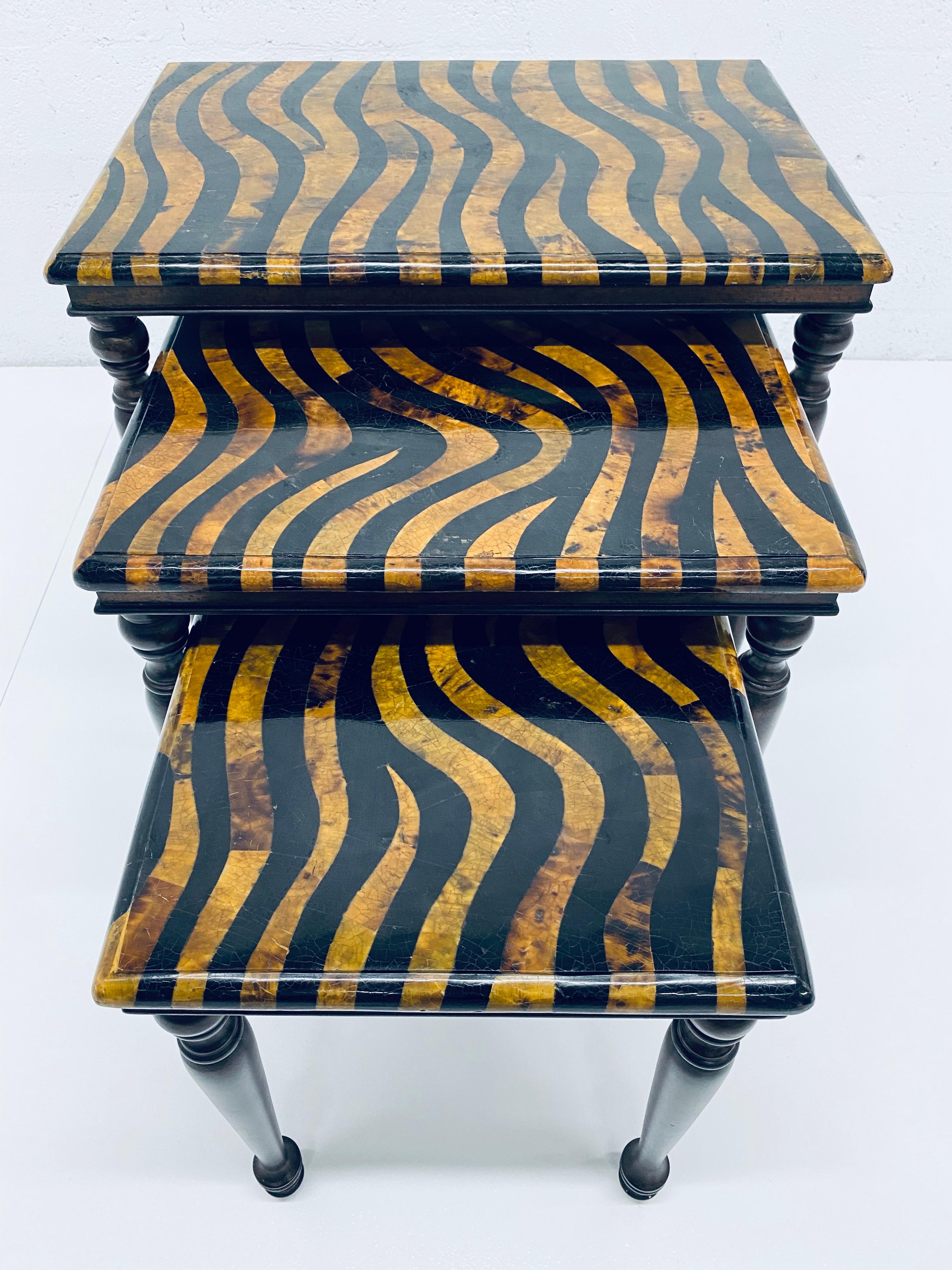 Set of three nesting tables rendered in cracked coconut shell lacquer top with Zebra motif and wood legs by Maitland-Smith.