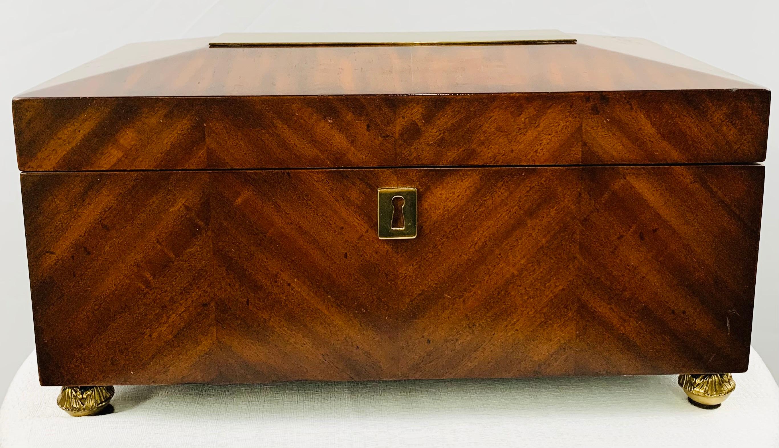 An elegant 1970s large mahogany wood box signed Maitland Smith. The box features fine brass rectangular design on the top and gilded round feet. This timeless box will decorate your room and is large enough to store many items such as cigars,