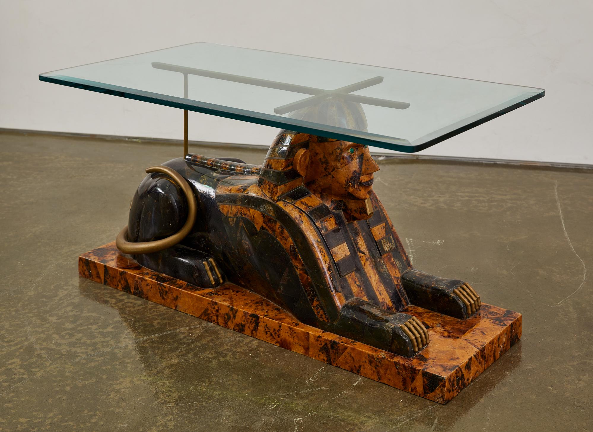 Cette pièce a été produite par Maitland-Smith vers les années 1970. Il s'agit d'une pièce moderne réalisée dans le style néo-égyptien. La table est dotée d'un plateau en verre amovible avec des coins arrondis et un bord biseauté. La base de la table
