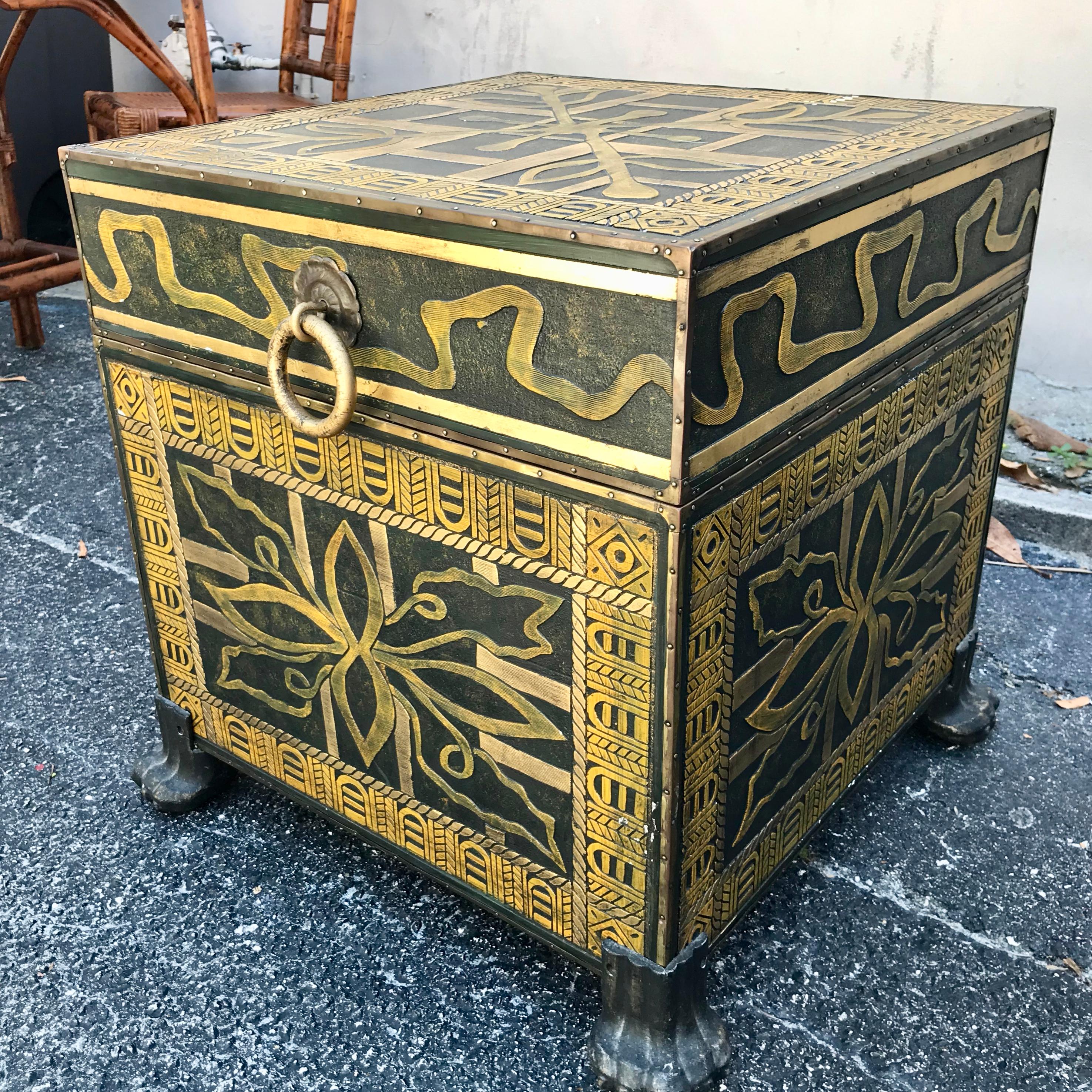 A cube form storage box with an elaborate embossed metal surface.
The box is raised upon Lion's paw feet.
A dramatic and highly stylized piece.