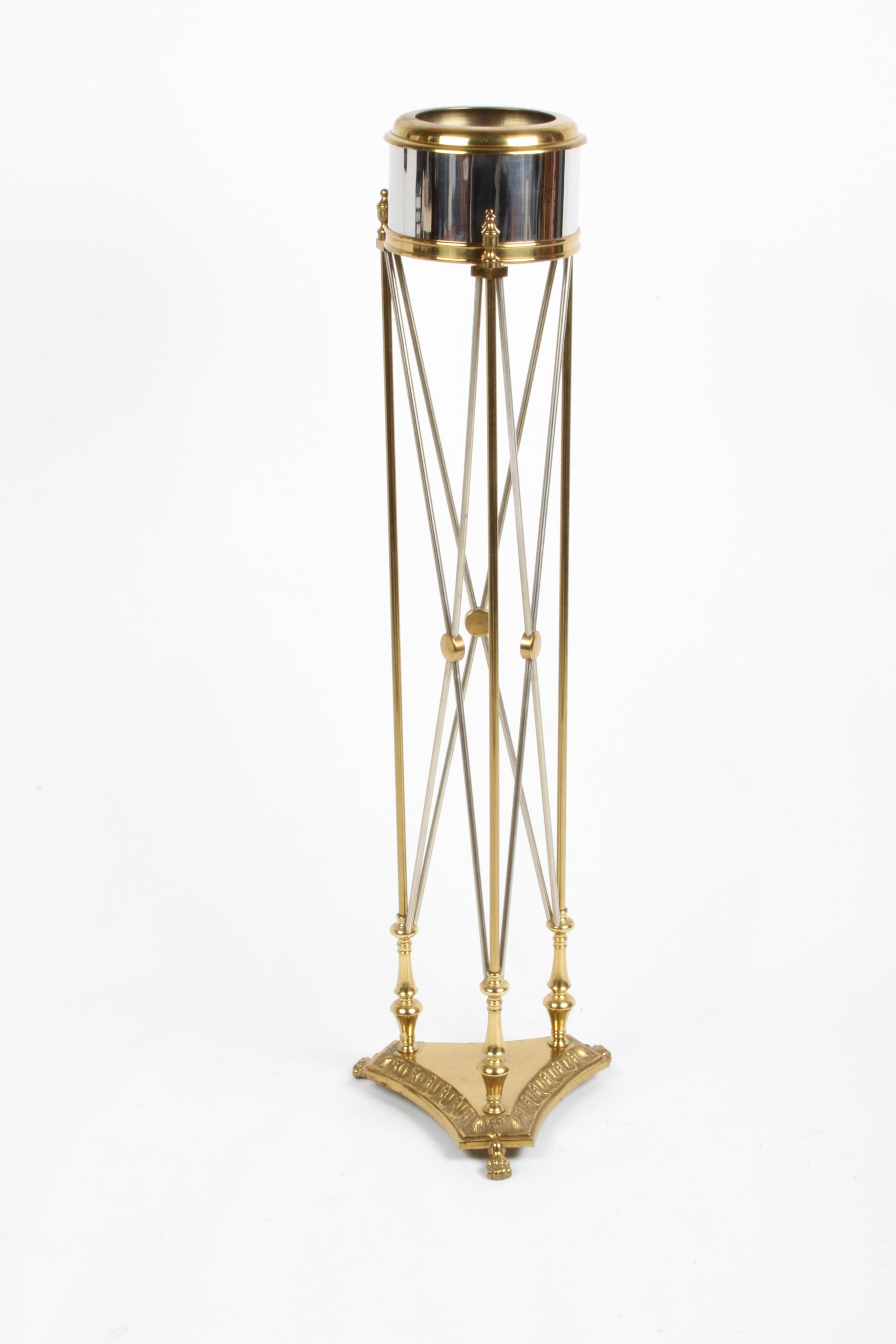1980s vintage jardinière in the Empire style manufactured by Maitland-Smith with cylindrical polished-chrome planter trimmed with brass. Planter connects to cast tripod brass base with claw feet by Directoire style intersecting chrome rods with