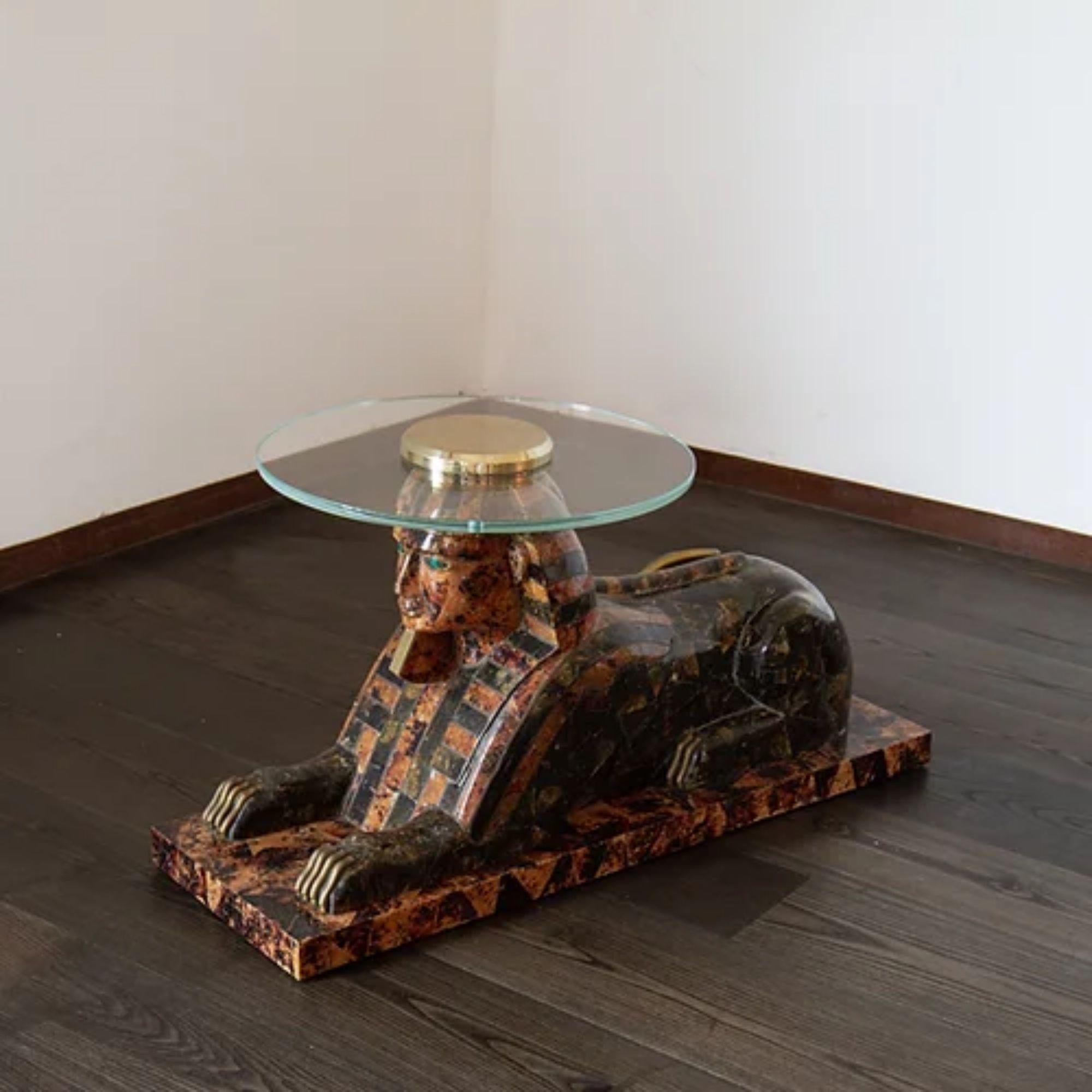 A Maitland Smith designed exotic Sphinx side table in tessellated marble and coconut shell decorated with brass banding, featuring inset malachite eyes and a tarnished brass tail, feet and beard. The table is complete with a custom circular glass