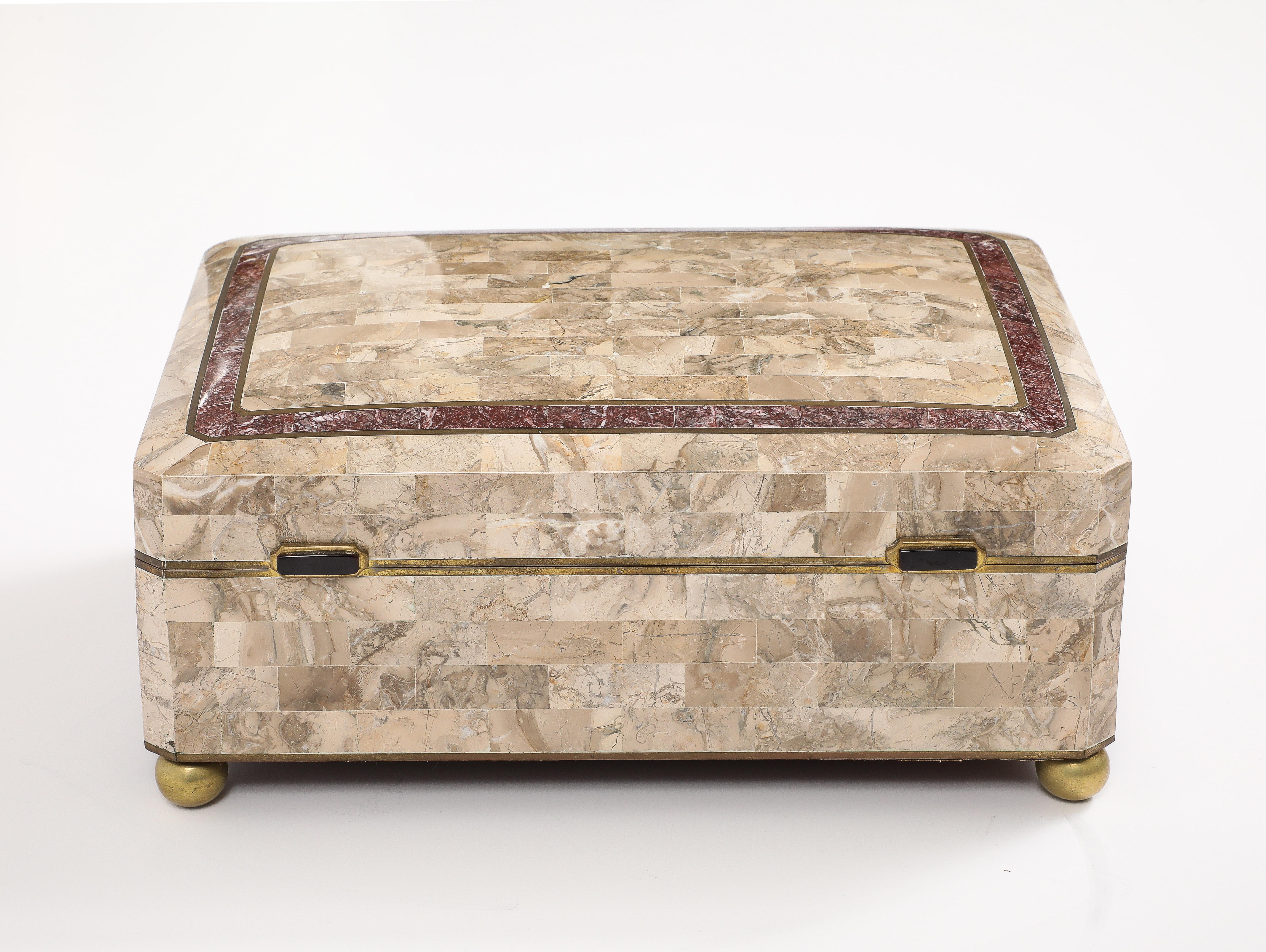 Wonderful Extra large Tessellated Travertine and Marble box by Maitland Smith.
The hinged Travertine box  is complemented by a burgundy border  with brass inlays, 
The box sits on brass ball feet  and has a chocolate brown suede interior and
retains