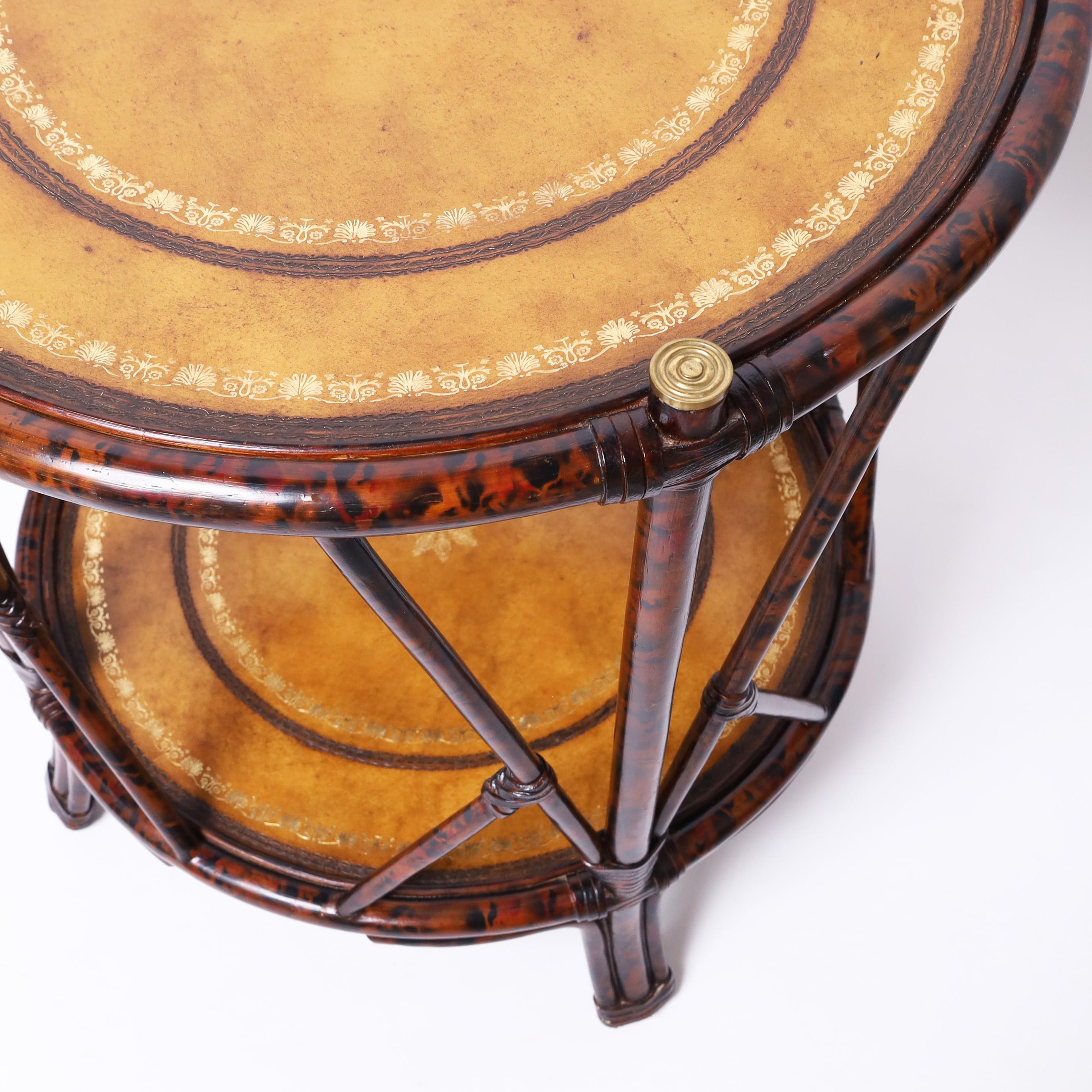Table d'appoint ou support vintage en faux bambou avec une finition en fausse tortue, des capuchons en laiton et deux niveaux de plateaux en cuir tolé. Comme le montre la dernière photo de l'annonce, une table similaire est également disponible,