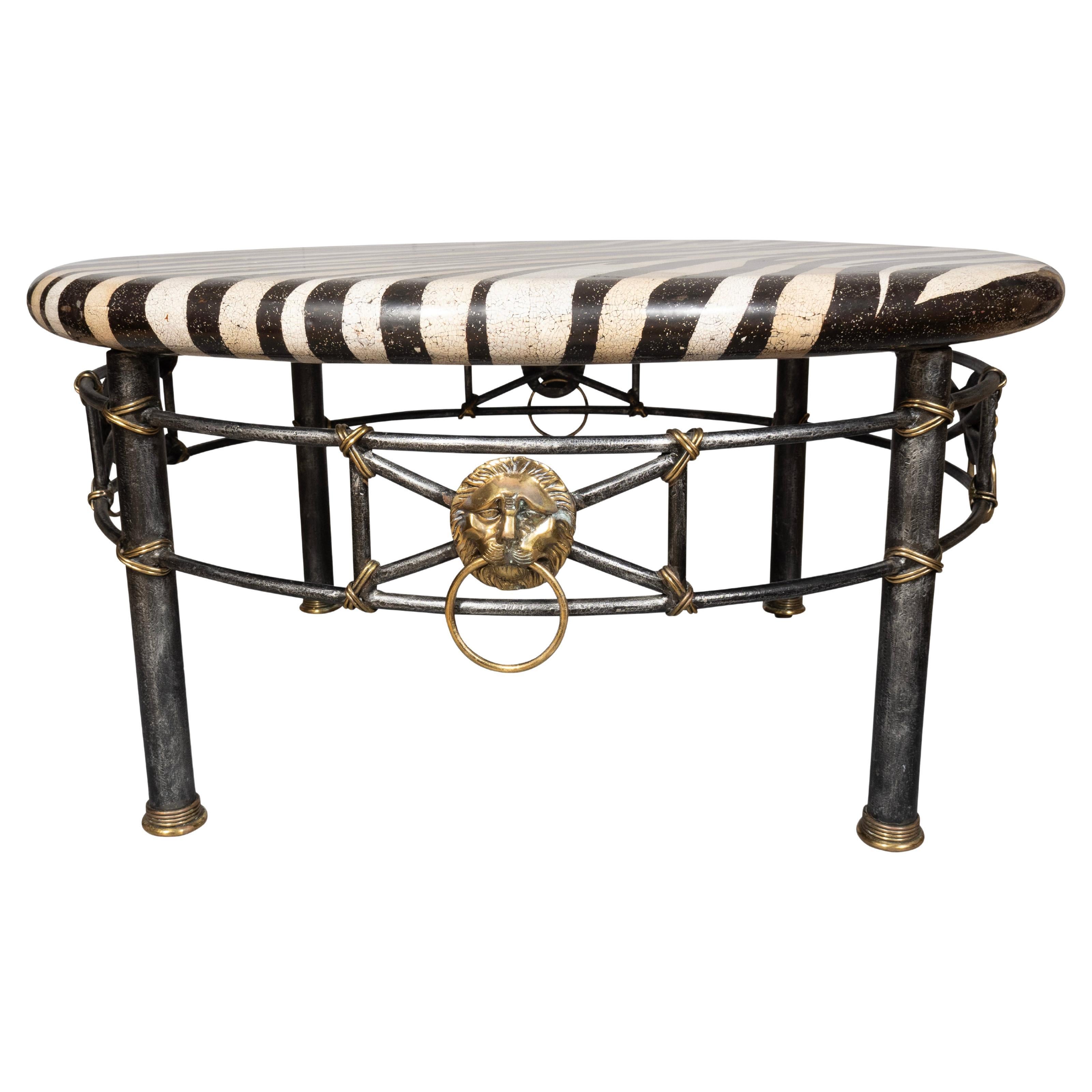 Circular faux eggshell lacquer with zebra pattern. Iron base with brass lions heads. Tubular legs.