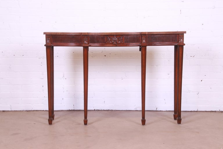 A gorgeous Federal style bow front console table or sofa table

By Maitland Smith

Late 20th Century

Carved mahogany, with embossed leather top.

Measures: 48