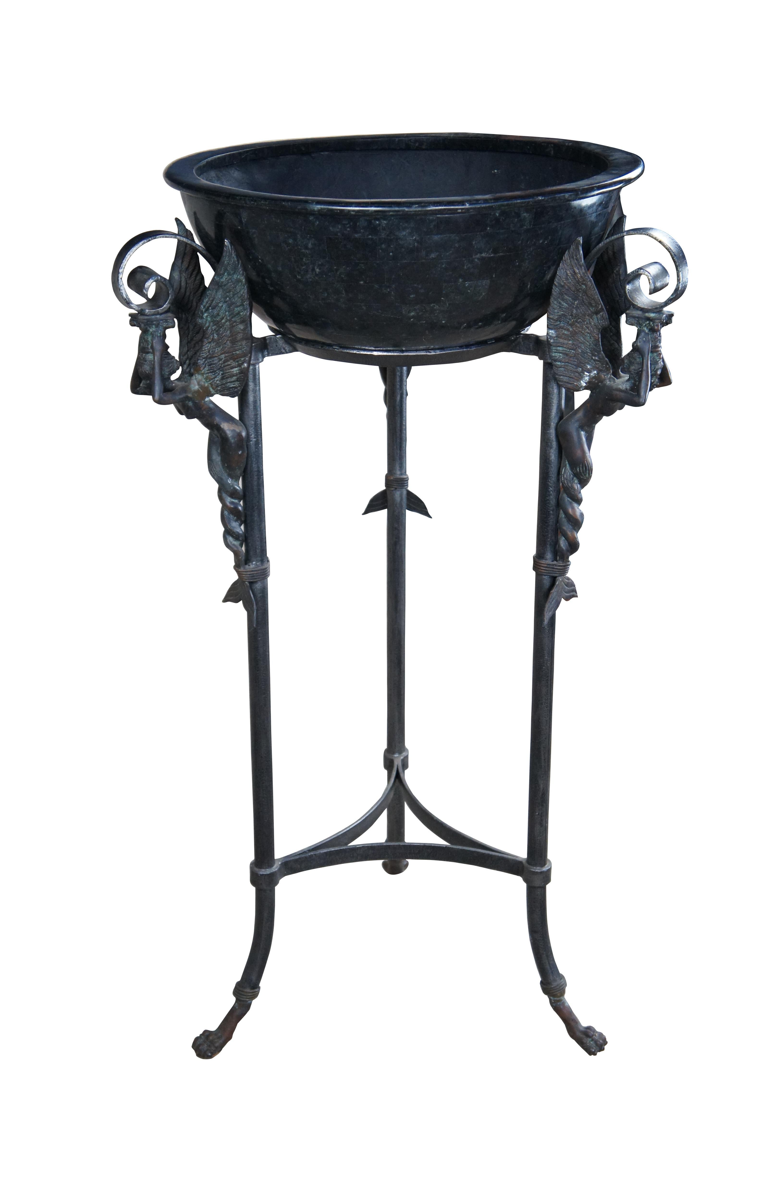 An impressive cauldron or planter by Maitland-Smith, circa 1990s. Made from iron and bronze in French Empire styling. Features a tessellated marble plater or bowl over a figured scrolled iron and bronze tripod base. The stand features figural winged