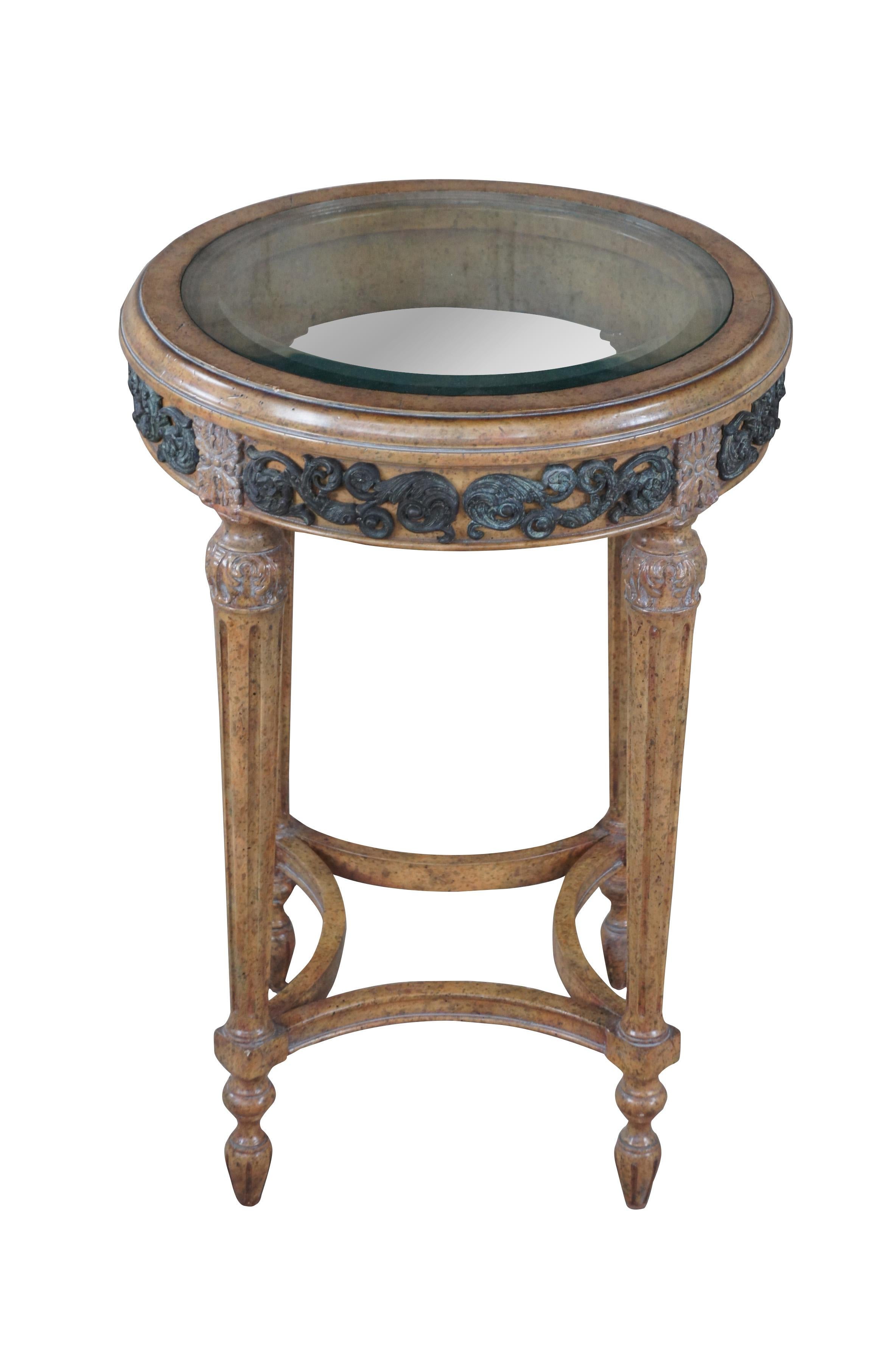 Vintage Maitland Smith French Louis XVI Gueridon / martini side table.  Fabriquée en noyer, elle présente une forme ronde avec un plateau en verre biseauté, des accents floraux et d'acanthe, et des pieds fuselés et cannelés.

Dimensions :
18