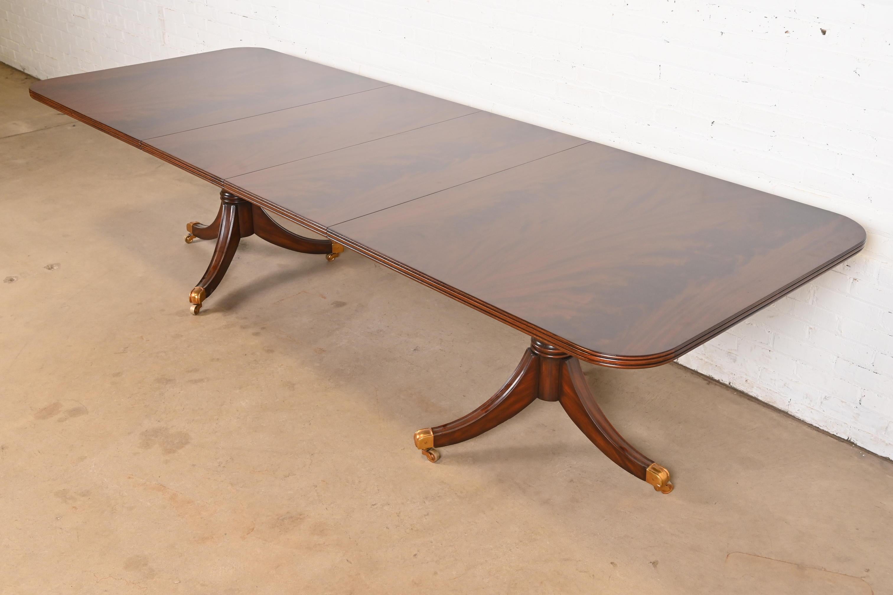 An exceptional Georgian or Regency style double pedestal extension dining table

By Maitland Smith

Philippines, Late 20th Century

Gorgeous book-matched flame mahogany, with carved solid mahogany pedestals, and brass-capped feet on brass