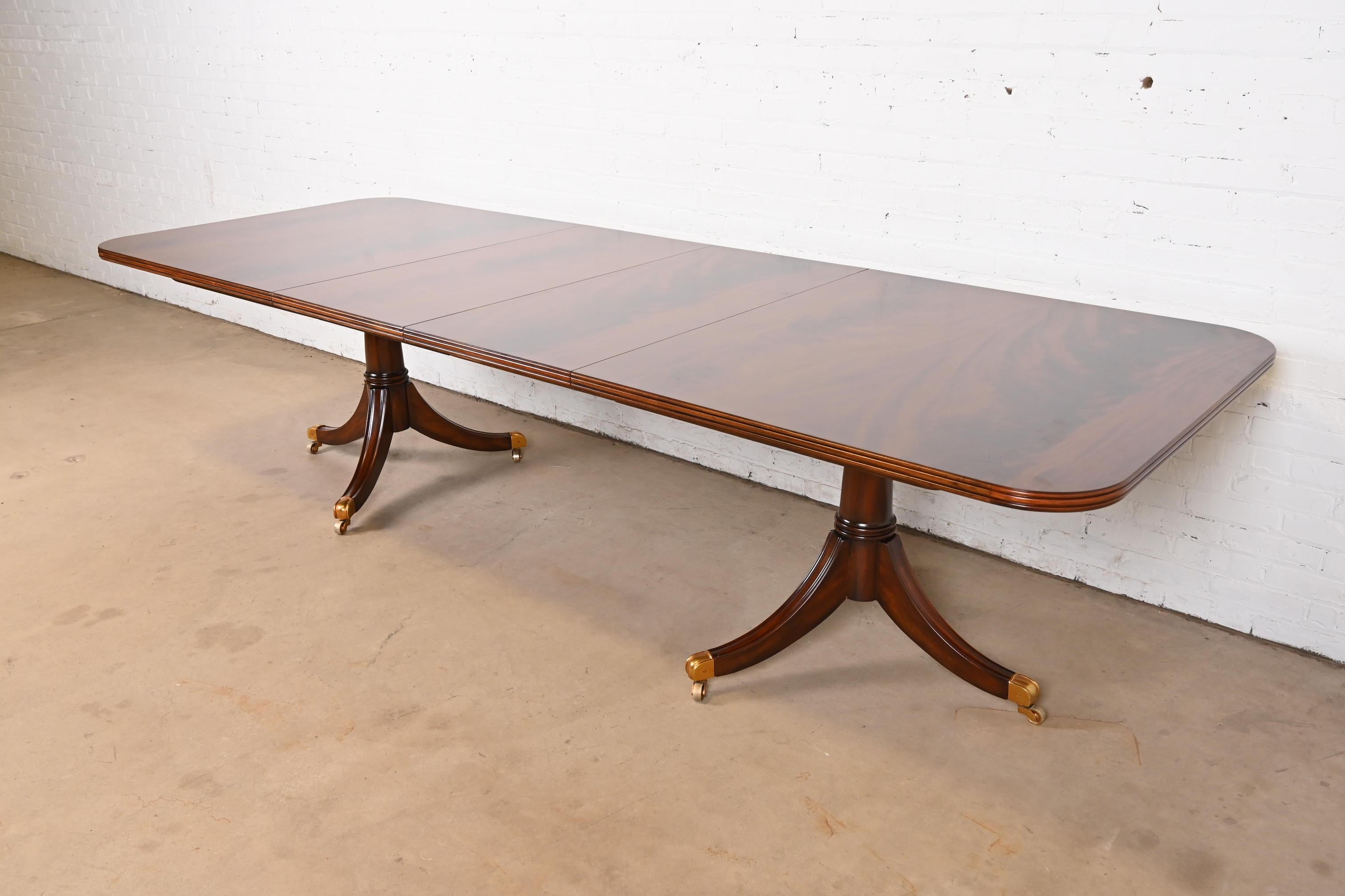 An exceptional Georgian or Regency style double pedestal extension dining table

By Maitland Smith

Philippines, Late 20th Century

Gorgeous book-matched flame mahogany, with carved solid mahogany pedestals, and brass-capped feet on brass