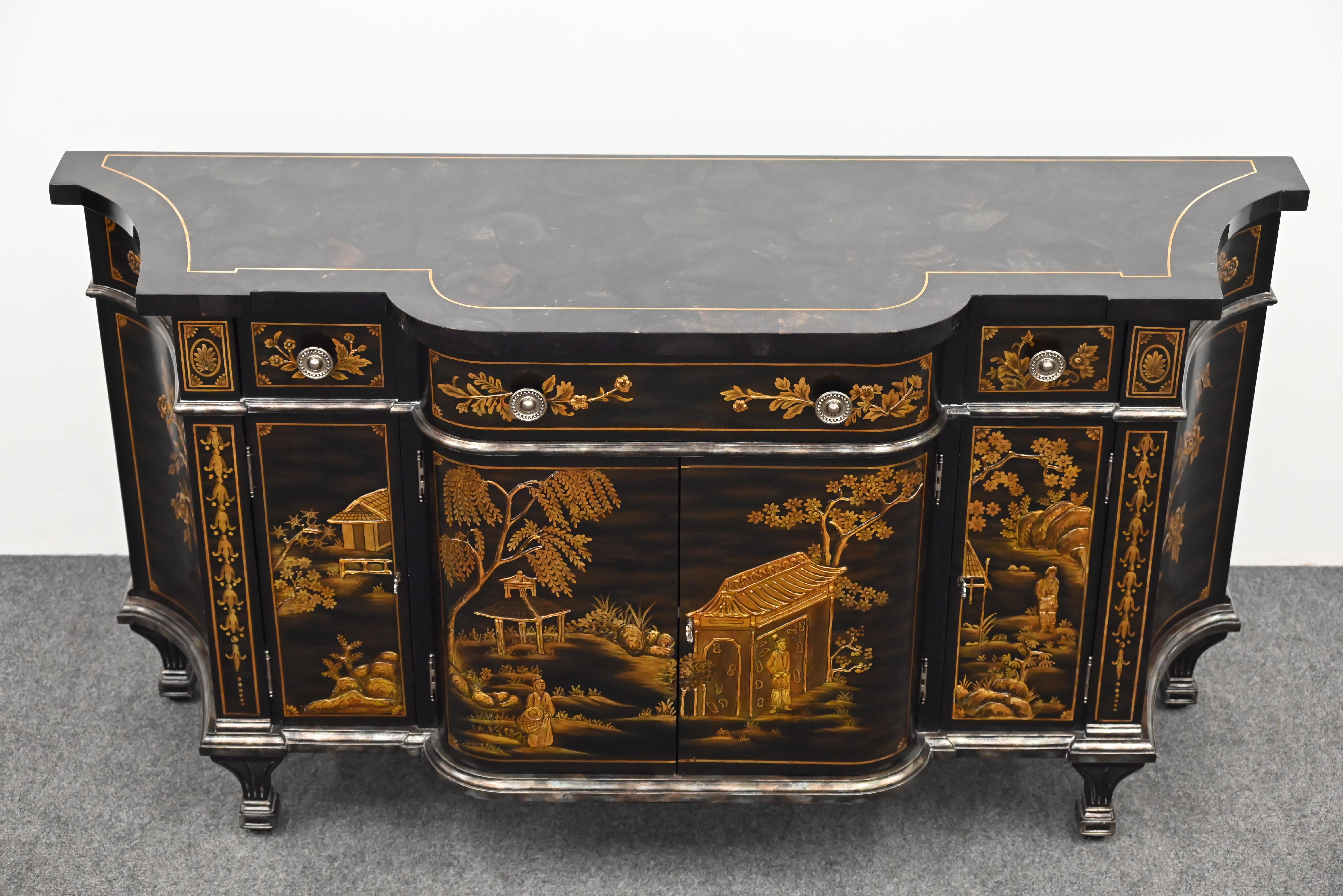 A stately black and gold gilt chinoiserie commode or credenza by Maitland Smith. This cabinet has a faux tessellated tortoise shell top and stylish fluted legs.  The sideboard also has a touch of silver leaf finish accentuating the piece. There are