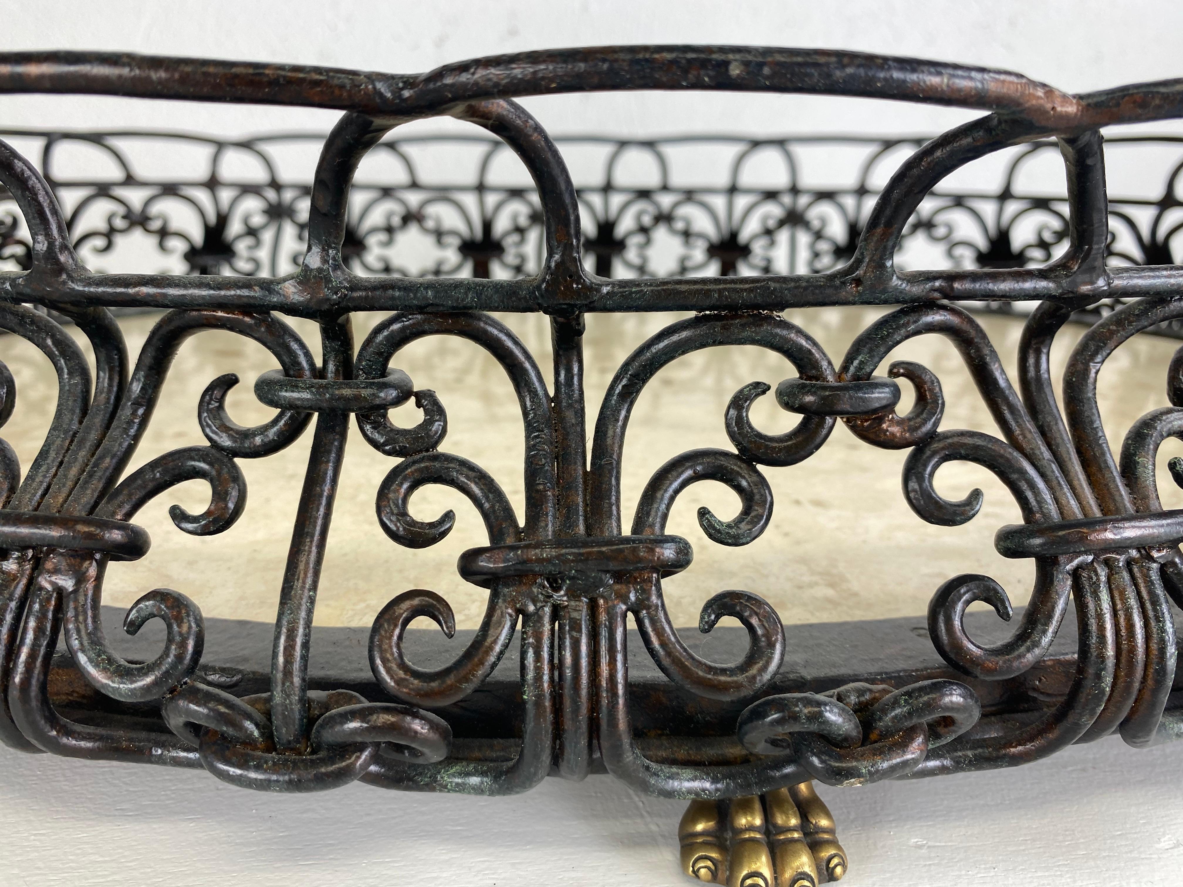 This is a late 20th century hand wrought iron French style serving tray by Maitland Smith. The serving tray has hand wrought iron delicately shaped into a Bombay form around the entire edge of the inlaid marble. This beautiful tray stands on four
