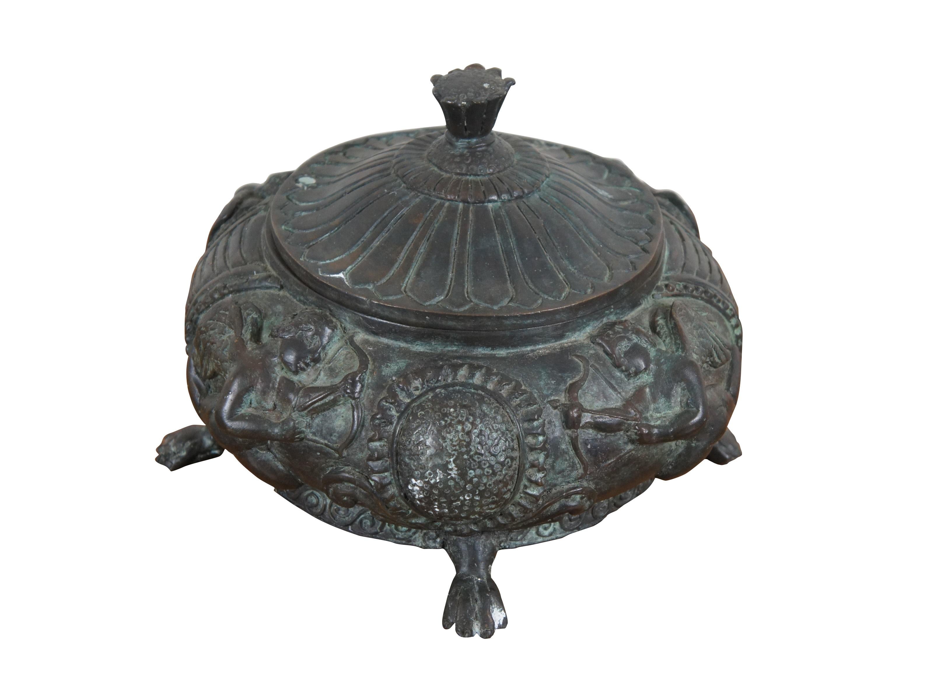 Rare vintage Maitland Smith bronze lidded and footed urn / compote featuring a low round form on paw feet, decorated with a Greek / Grecian design of cherubs in high relief, with a lid shaped like a sunflower.

Dimensions:
11.5