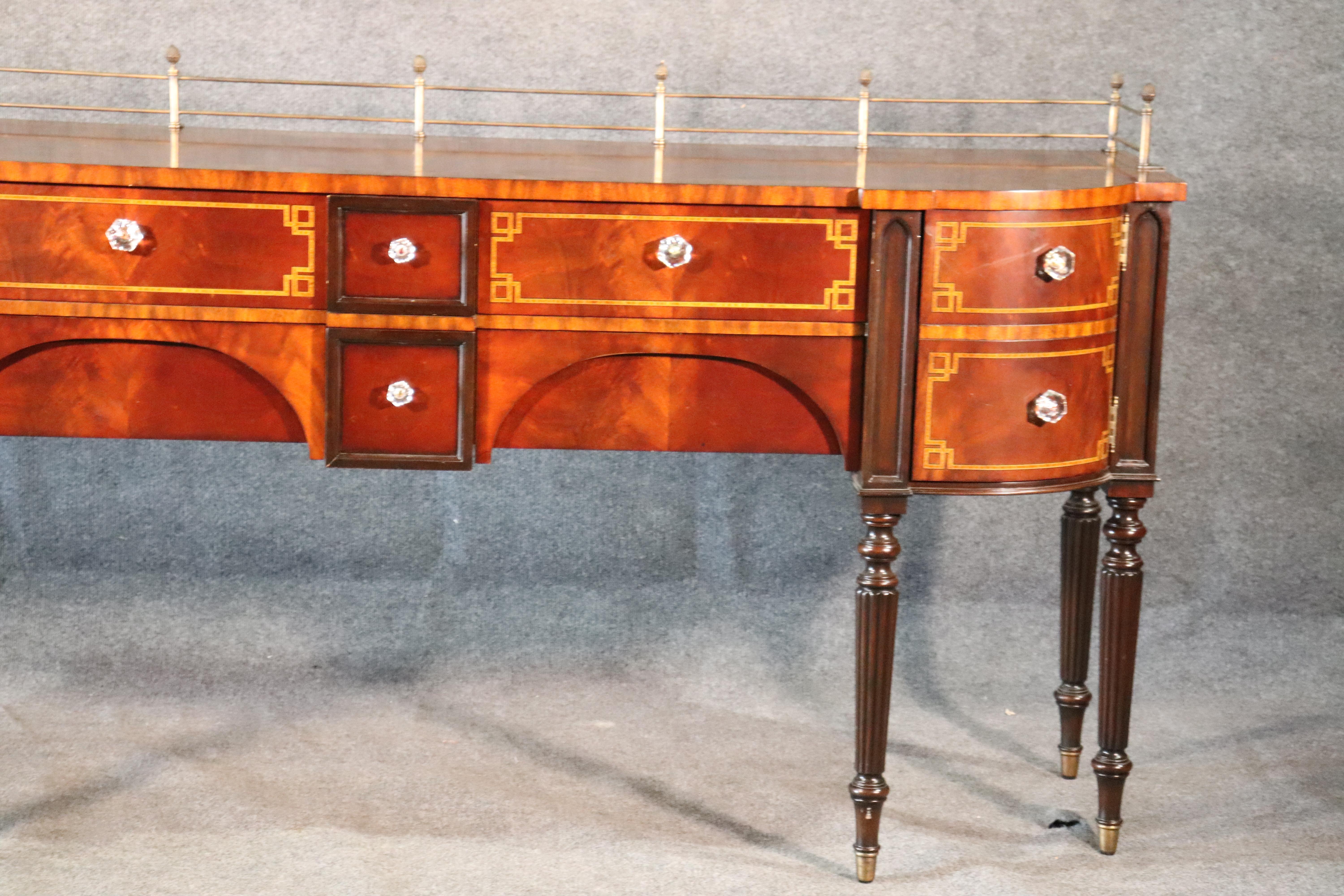 This is a gorgeous antique-looking Maitland Smith Sheraton sideboard with a removable brass gallery. The sideboard has glass pulls and was really well designed to accurately replicate an authentic antiques.

Measures: 84 wide x 42.75 tall x 24