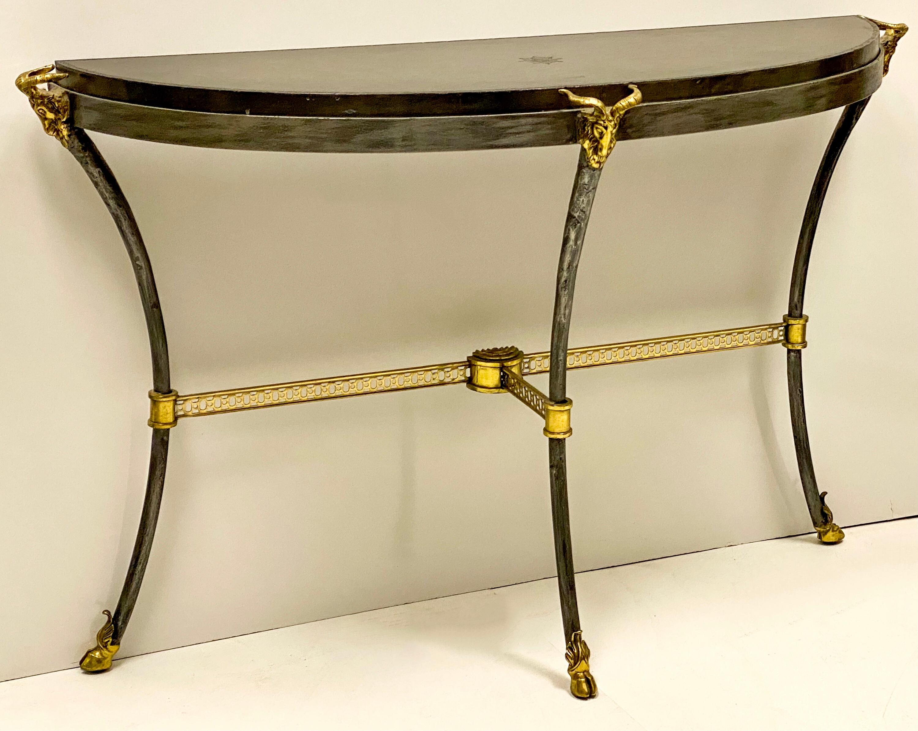 This is a neo-classical style console table by Maitland-Smith. It has an unusual gray tooled leather top. The base is iron with brass ram appointments. It is marked and in very good condition.