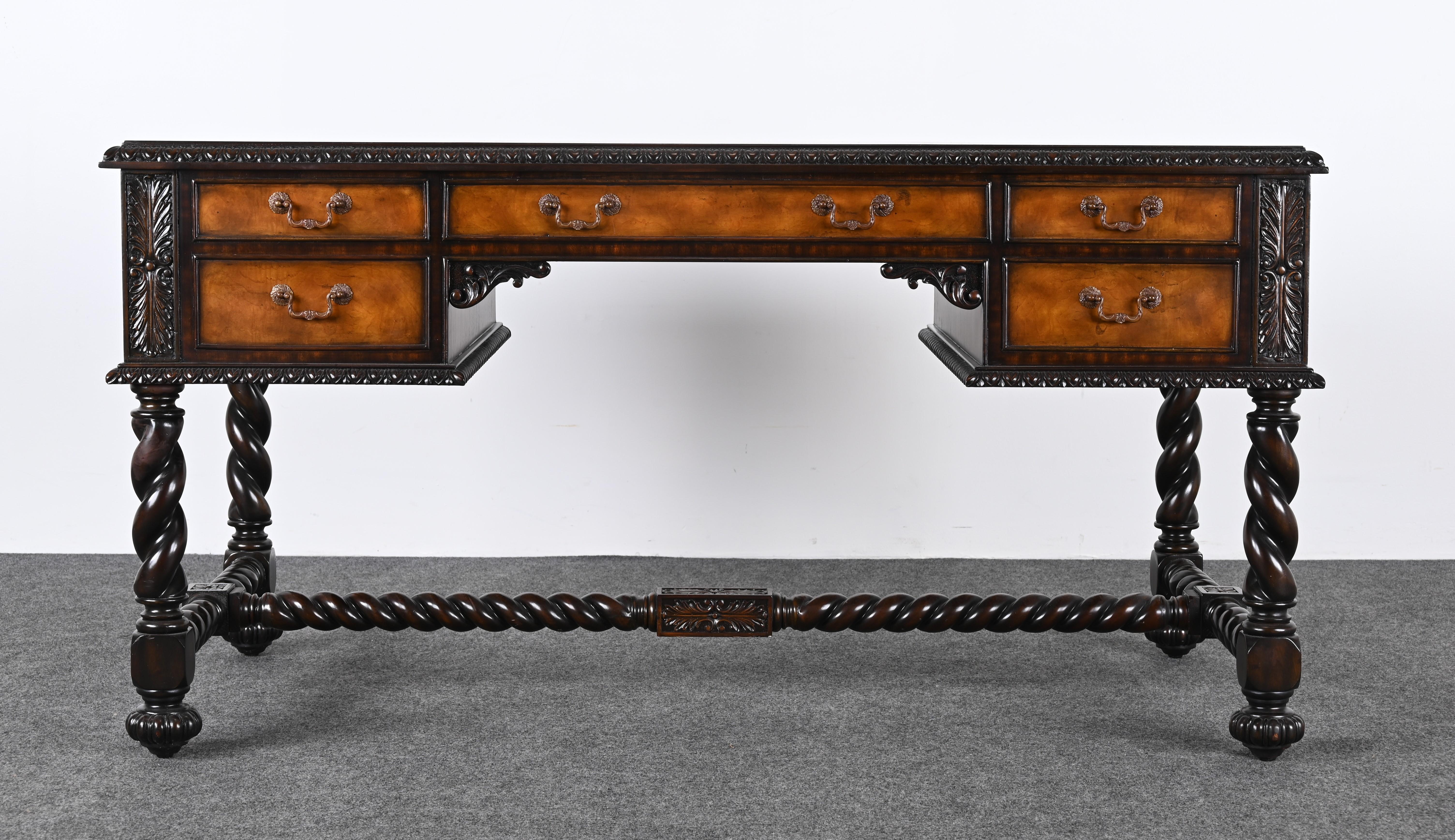 A handsome Jacobean style desk with barley twist legs & stretchers, embossed leather top with burled side panels and an egg & dart decorative edge.  The Jacobean era in England was a significant period of transformation under the reign of King James