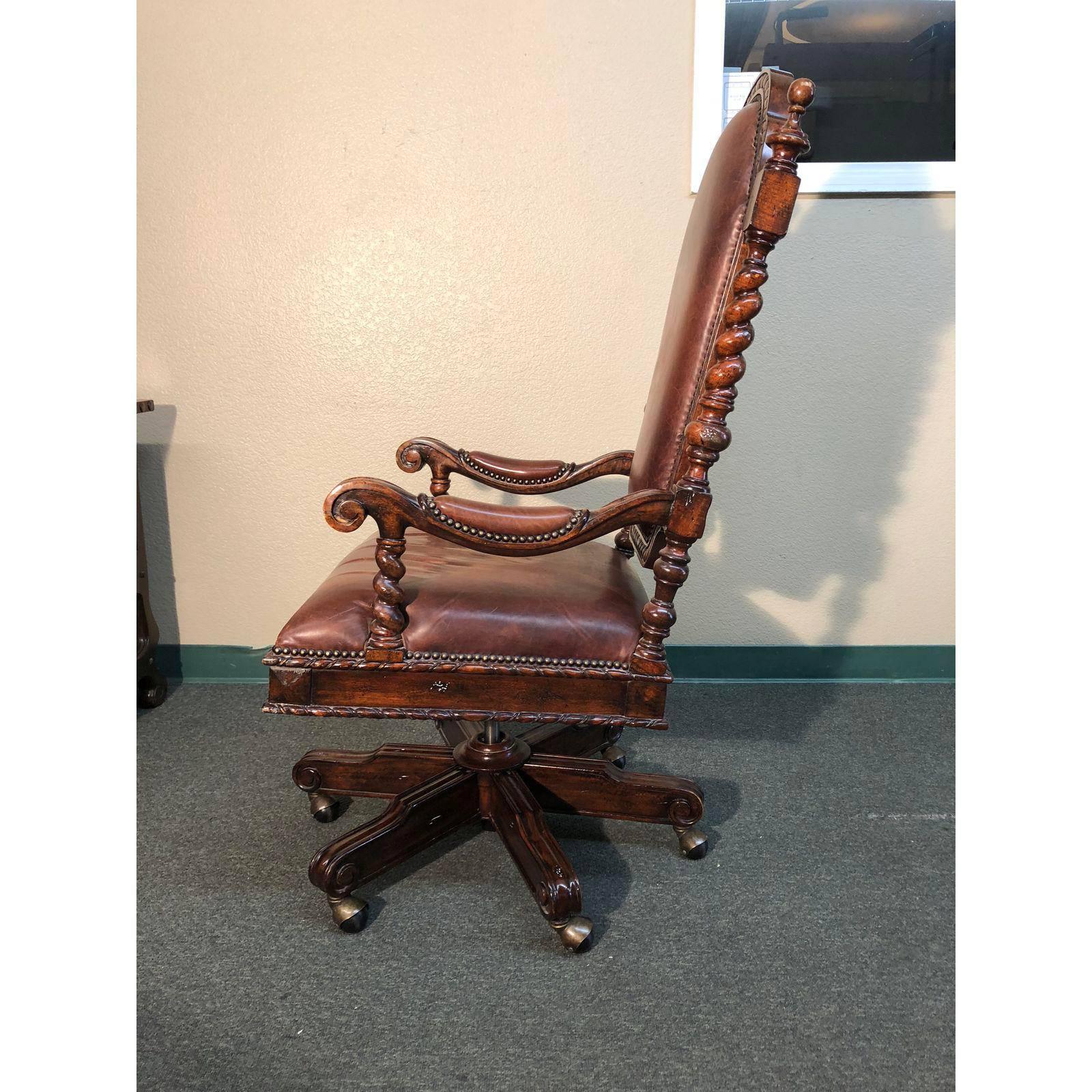 A Lido desk chair by Maitland-Smith. A natural to pair with an executive desk, the dark mahogany finished beauty is rich in details. Carved and distressed wood, barley twists, rich leather and antiqued nailhead all project earned success. Adjustable