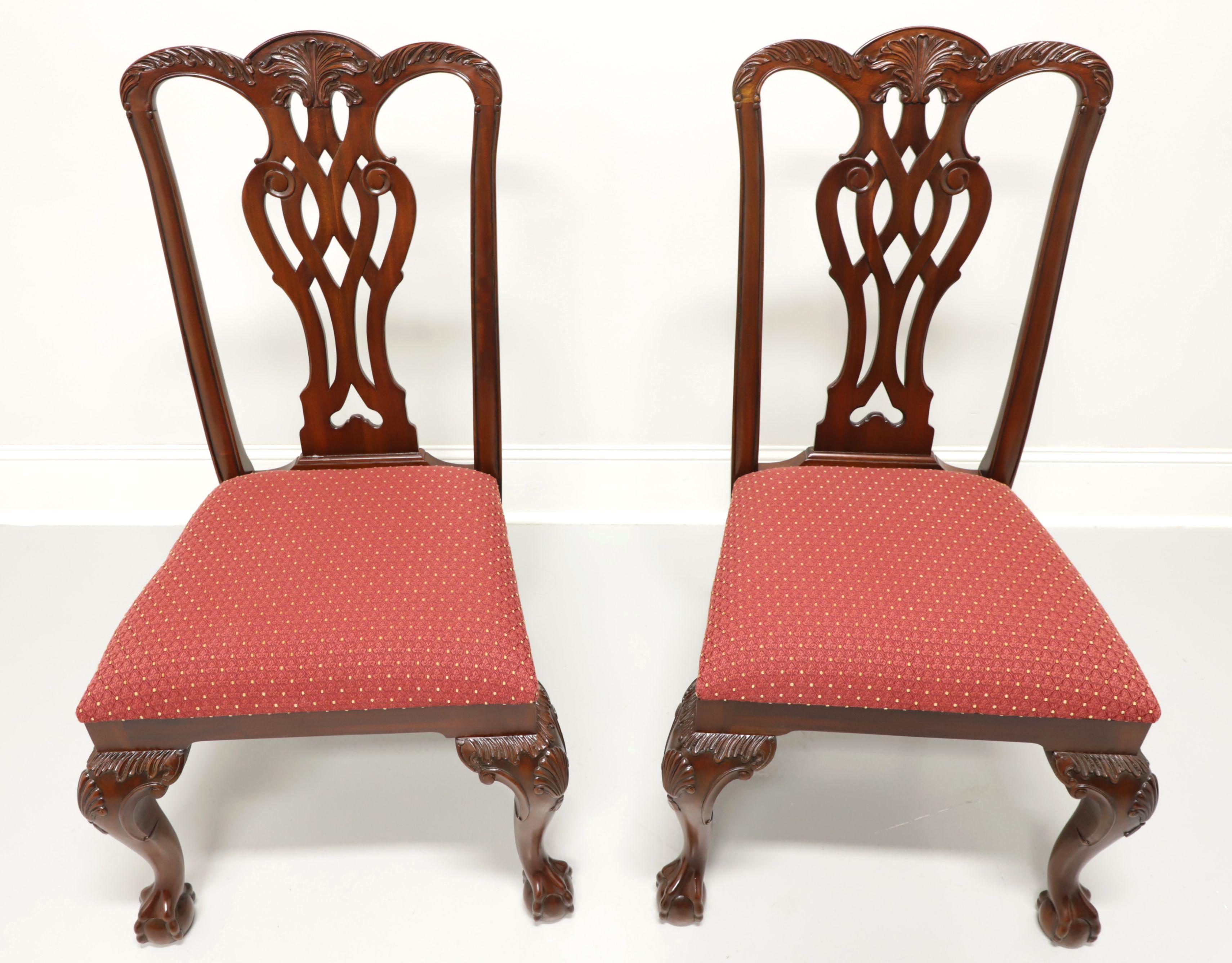 A pair of Georgian style dining side chairs by Maitland Smith. Solid mahogany with carved crest rails, carved back rests, red & gold color fabric upholstered seats, carved fan to knees, curved legs and ball in claw feet. Made in Indonesia, in the