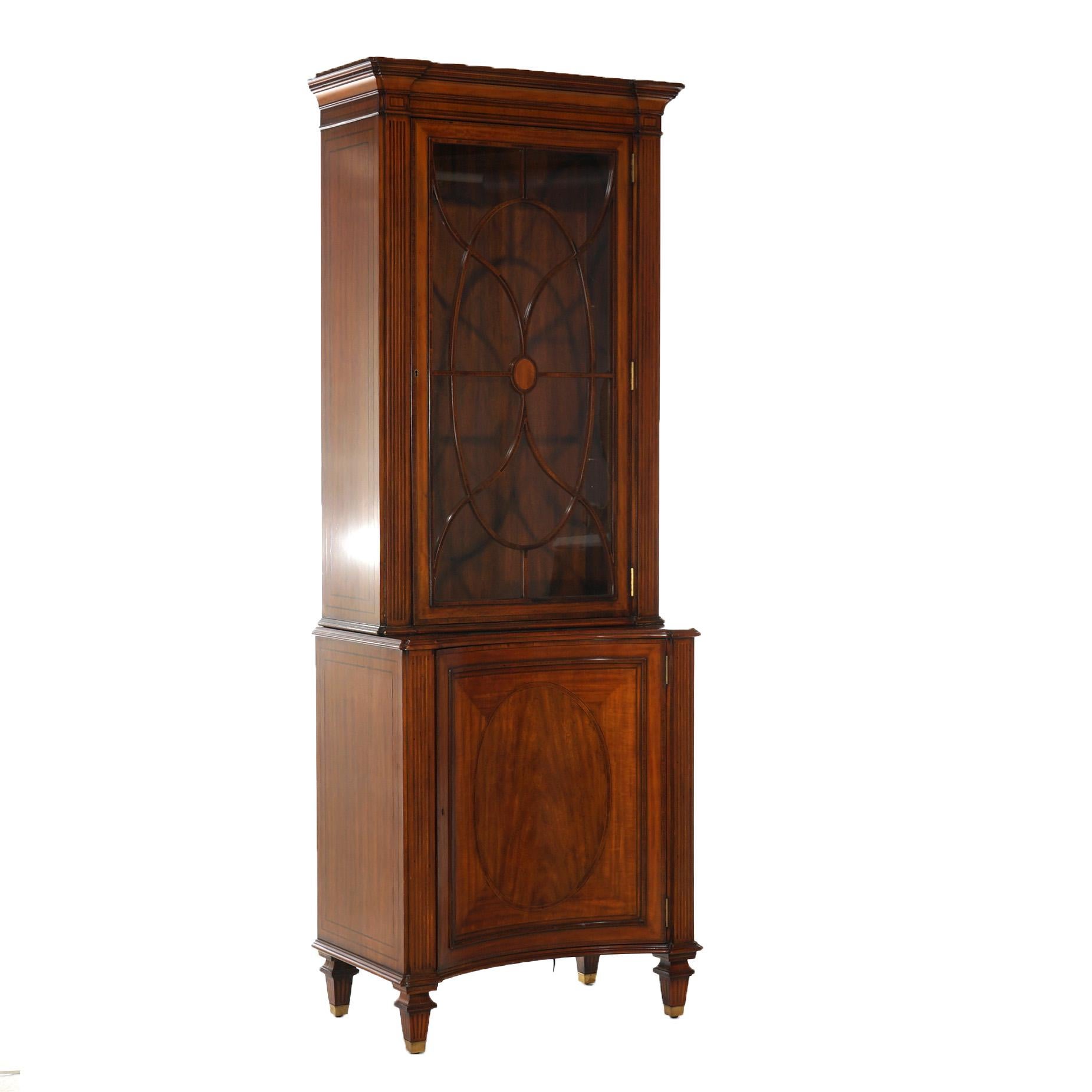A bookcase by Maitland Smith offers mahogany construction with upper having single glass door opening to shelved interior over lower blind concave door cabinet with inlaid and banded decoration, maker label as photographed, 20th century

Measures-