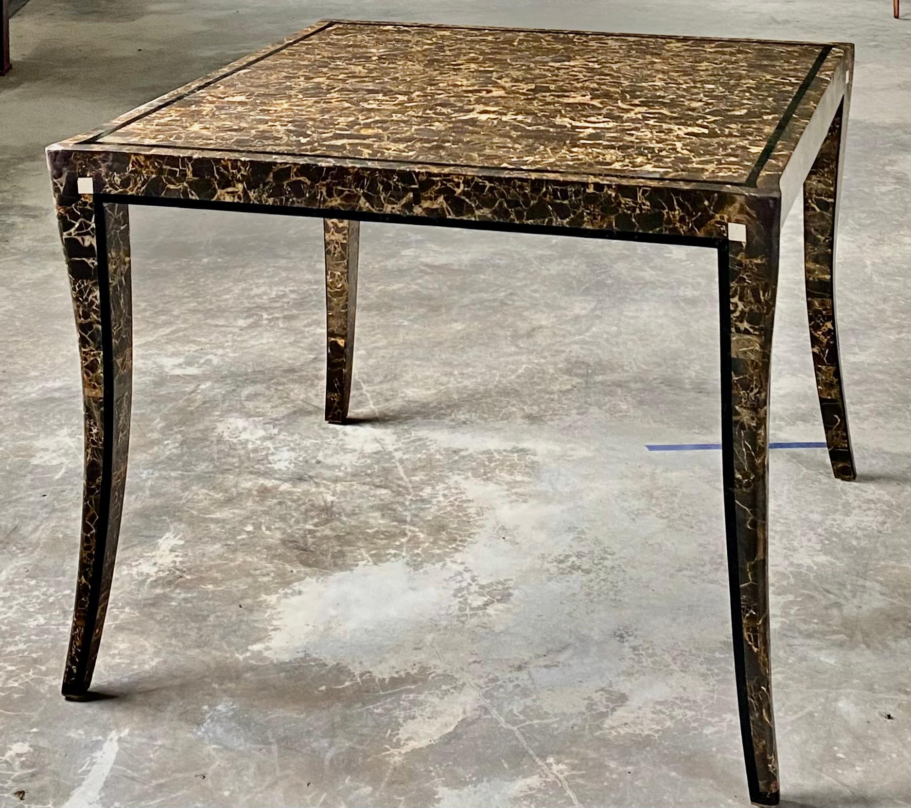 Rare to market, Maitland Smith tessellated marble game or breakfast table. An iconic design, with elegant splayed legs and a field of brown marble, bordered by black marble and ivory marble squares to punctuate each corner.

The brass at the very