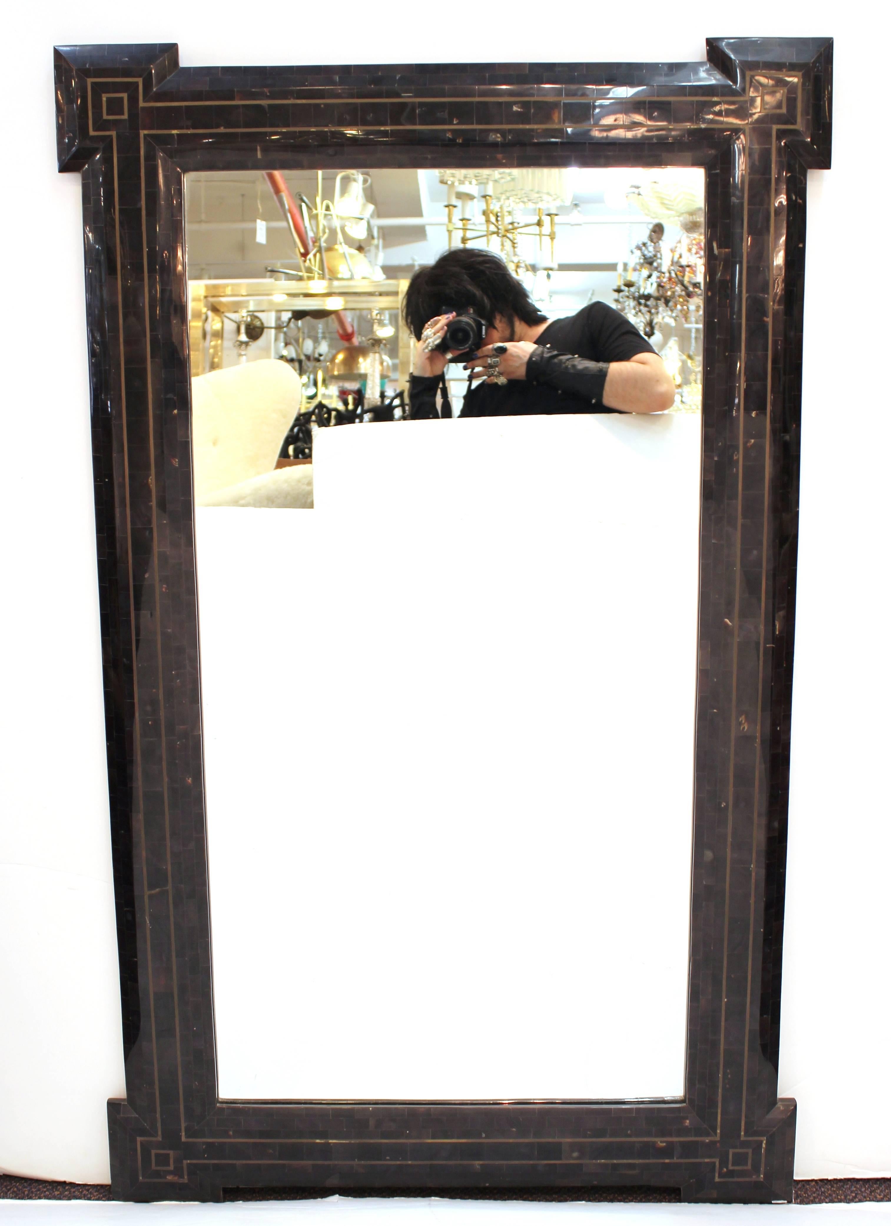 A Mid-Century Modern tessellated black wall mirror of neoclassical influence, made by Maitland-Smith. The piece is in good vintage condition and has a label on the back. A matching tessellated console is also available.