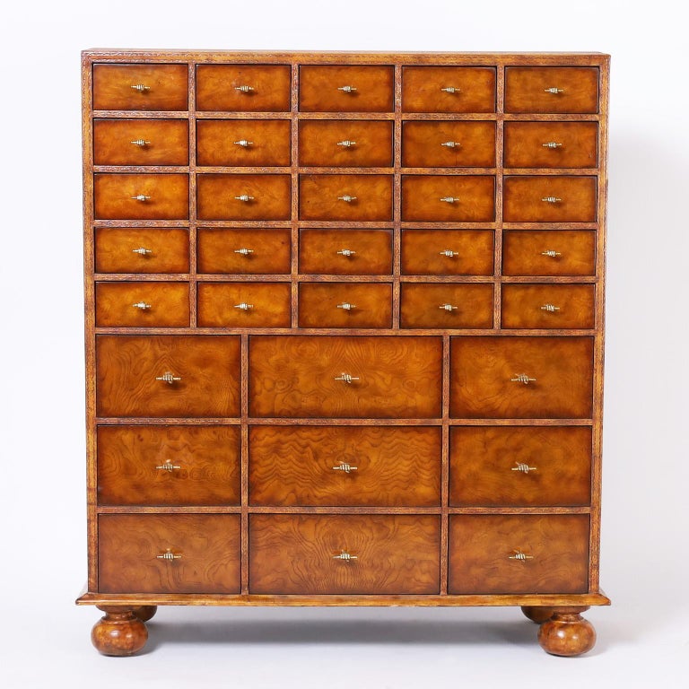 Rare and unusual chest of thirty four drawers featuring a case clad in tooled and gilt leather. Drawer fronts in burled walnut with brass stick & fist pulls and turned onion feet. Signed Maitland-Smith in a drawer.