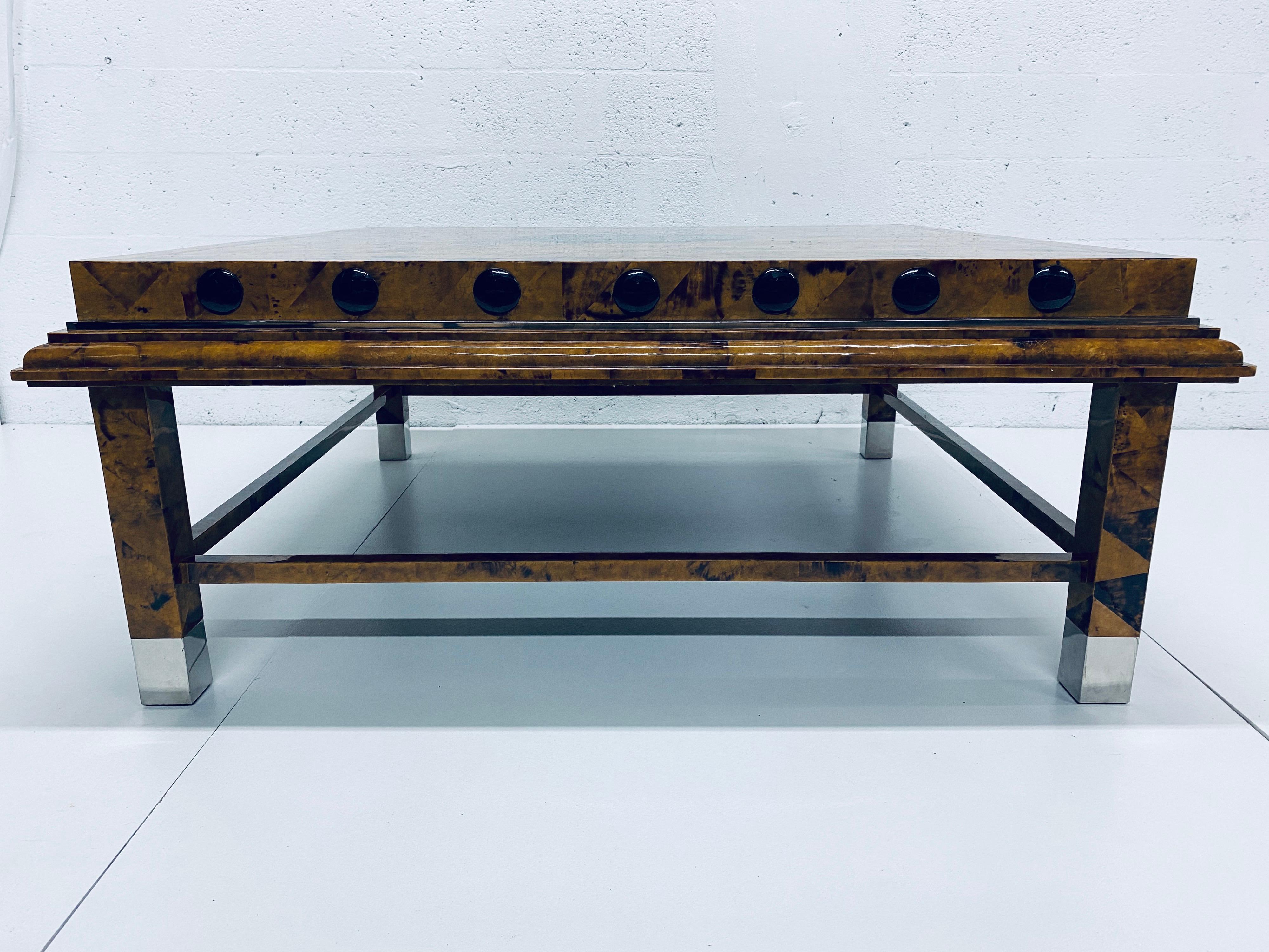 Monolithic tessellated cracked coconut shell coffee table by Maitland-Smith from the 1970s. The table is wrapped with a band of polished chrome and the feet are also wrapped in polished chrome. Exquisite, one-of-kind piece. We understand this piece