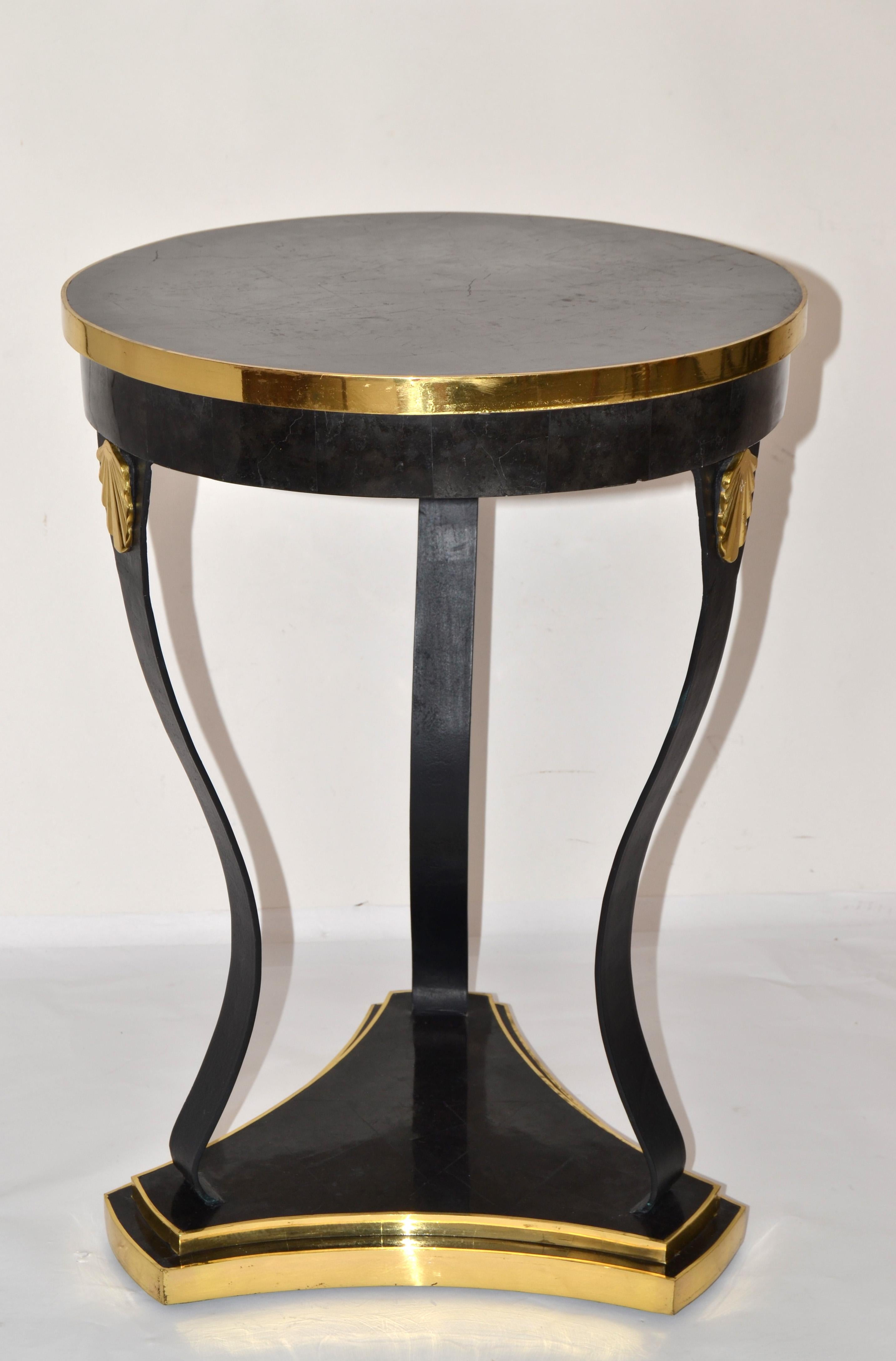 Superbe table ronde Maitland-Smith en fer forgé, bronze et pierre en marbre noir pour boire ou agrémenter un repas.
Le plateau est en pierre de marbre avec un motif de grain blanc d'une manière étonnante.
La tige du trépied est en fer forgé à la