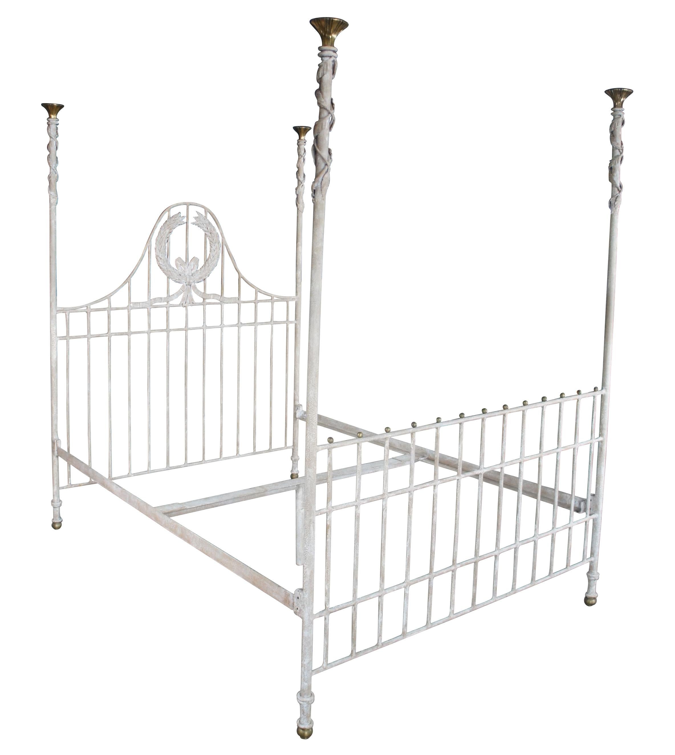 Late 20th century 4 poster bed by Lineage Home Furnishings for Maitland Smith. Made from wrought iron with a gridded form. The camelback headboard is centered by a large laurel wreath. Each long post is topped by brass torchiere over a leaf and vine