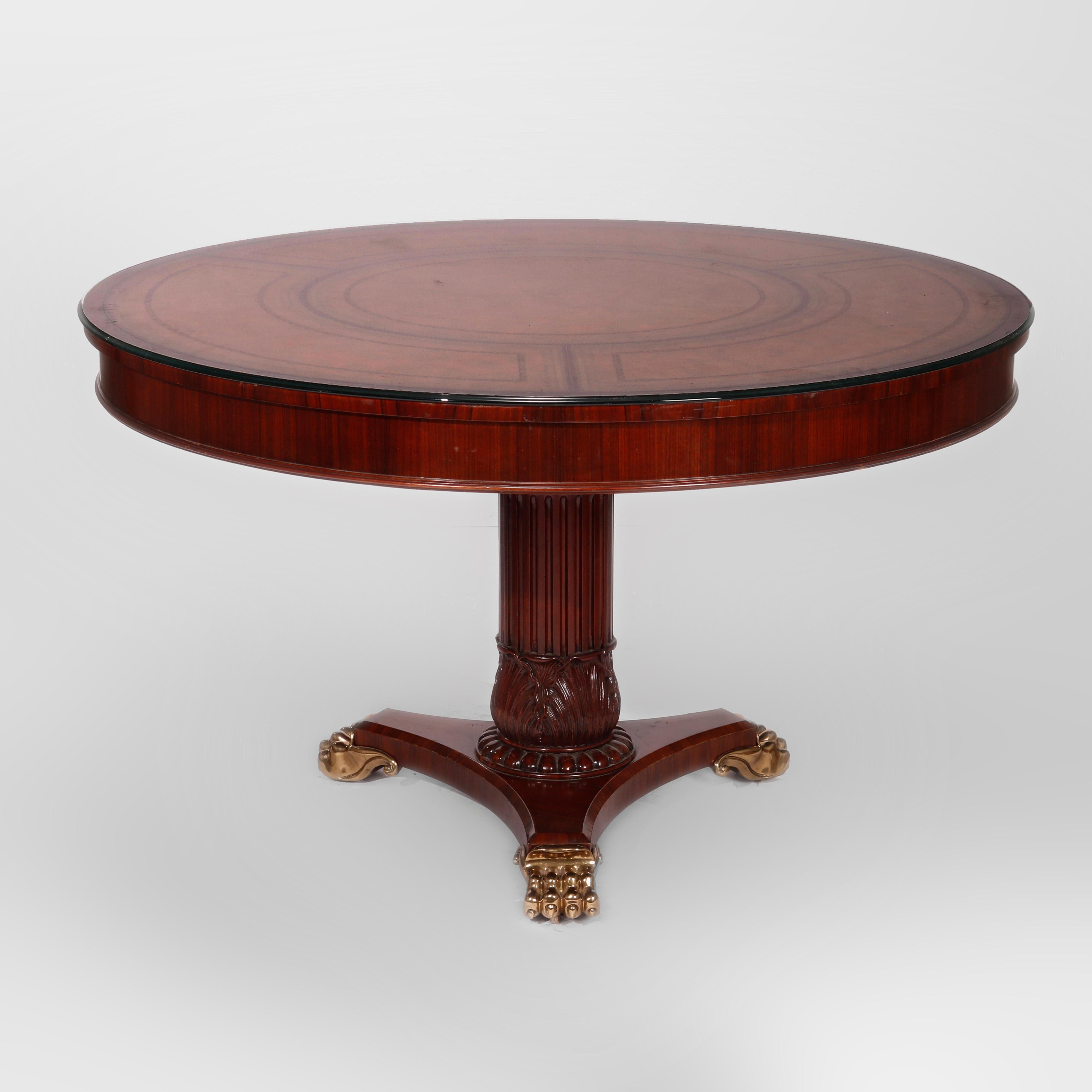 A neoclassical style center table by Maitland Smith offers rosewood and mahogany construction in circular form having tooled and gilt leather top over acanthus carved pedestal, raised on cast brass paw feet, maker label as photographed, 20th