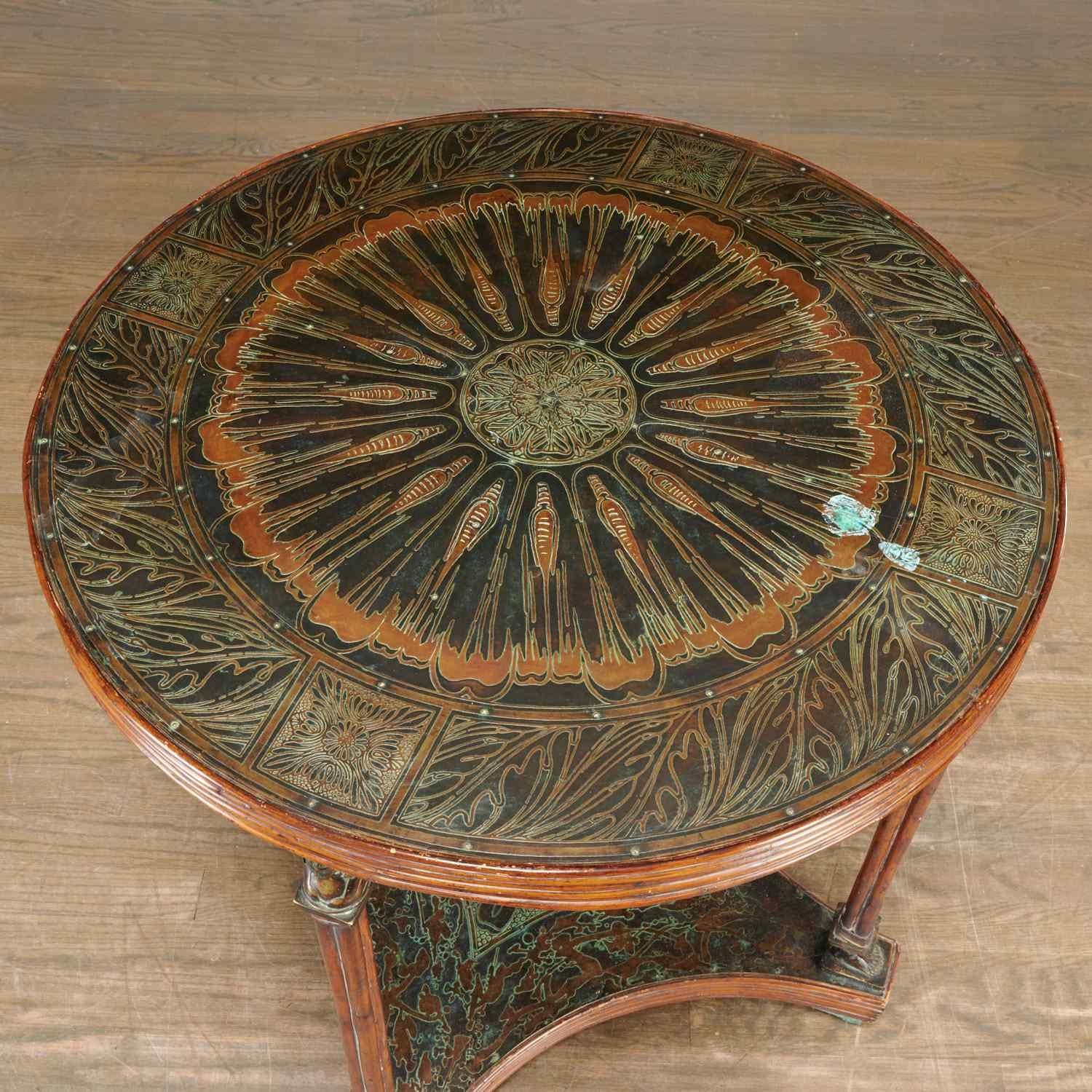 Striking Maitland-Smith handmade occasional table. c. 1970, two-tiers with a round top clad in etched sheet copper, with reeded bamboo trim, having classical maiden caryatid legs on a quatrefoil base, decorative patina matching the top. Foil sticker