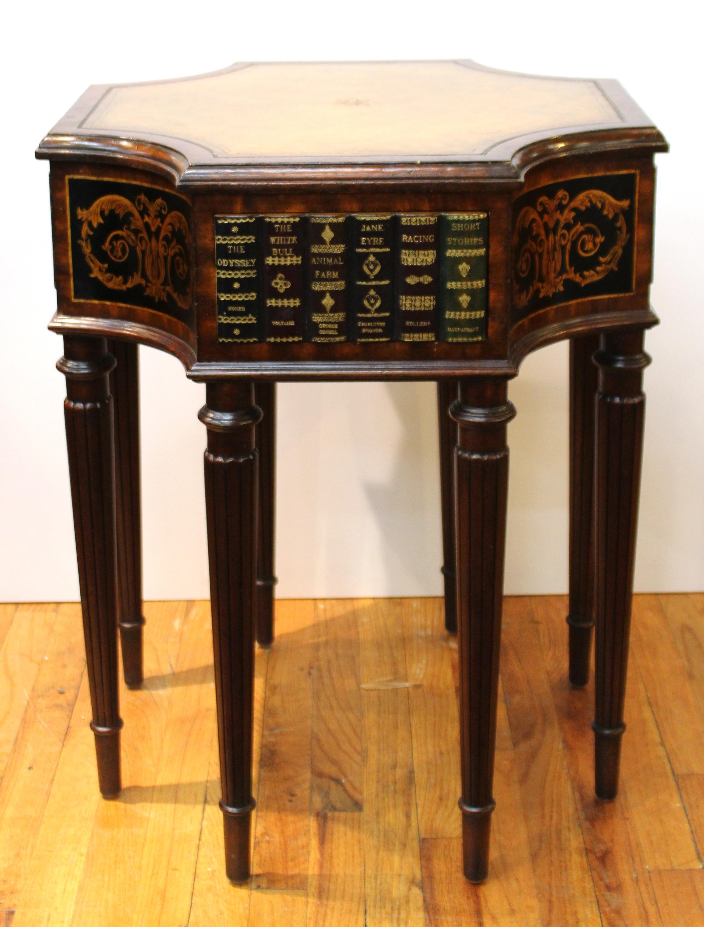 Maitland Smith neoclassical style center table or library table with faux book fronts on each side and a tooled leather top. Each book front opens up as a small drawer. Makers plaque in one of the drawers. The piece is in good vintage condition with