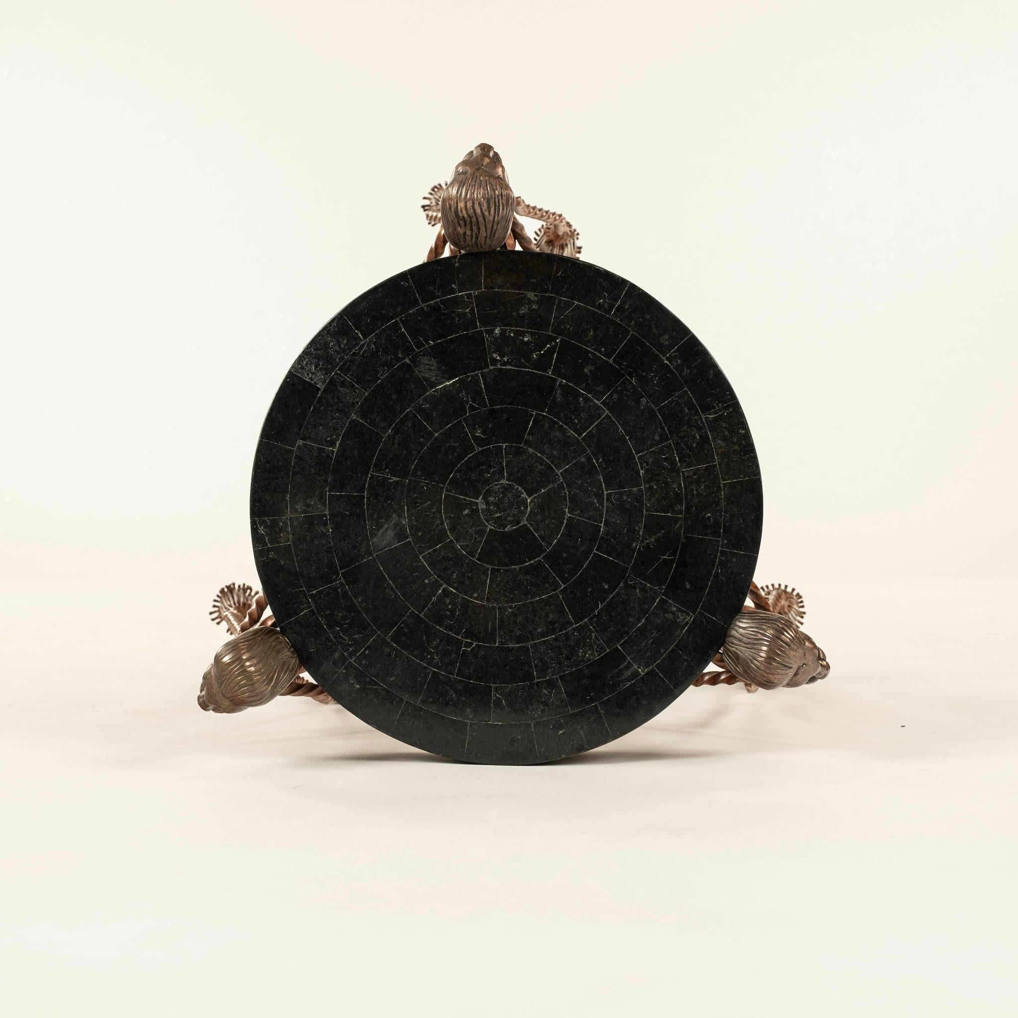 Pedestal de león de mármol teselado de estilo neoclásico Maitland Smith, con patas de hierro pintado con pies de pata de león y remates de cabeza de león, cuerda de hierro pintado y borlas. 