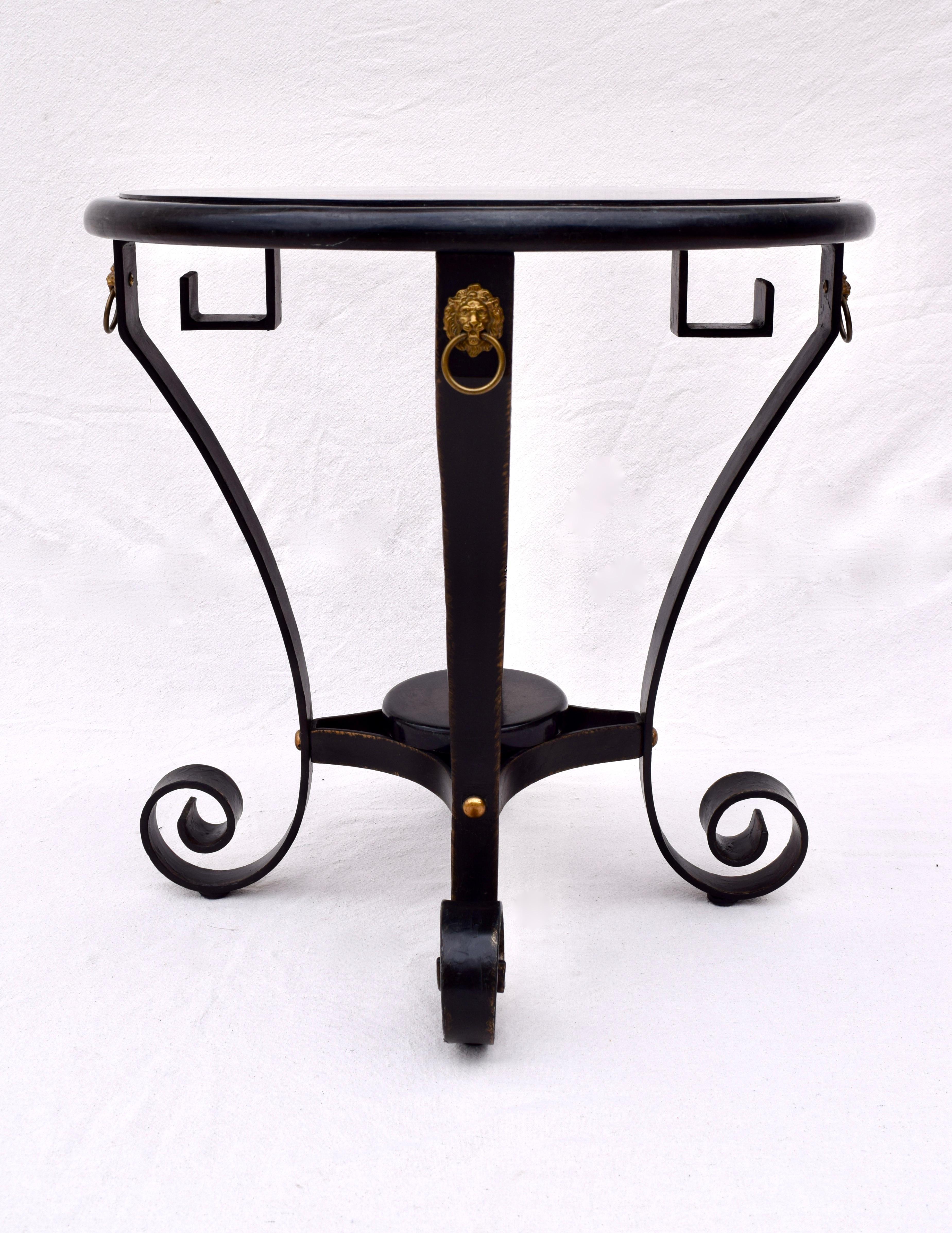Tessellated black with tortoise stone & shell Neoclassical style table by Maitland Smith. Aesthetically striking in its' forged iron base with Greek Key design embellished with brass lion heads detailing. A multifunctional option useful in a various