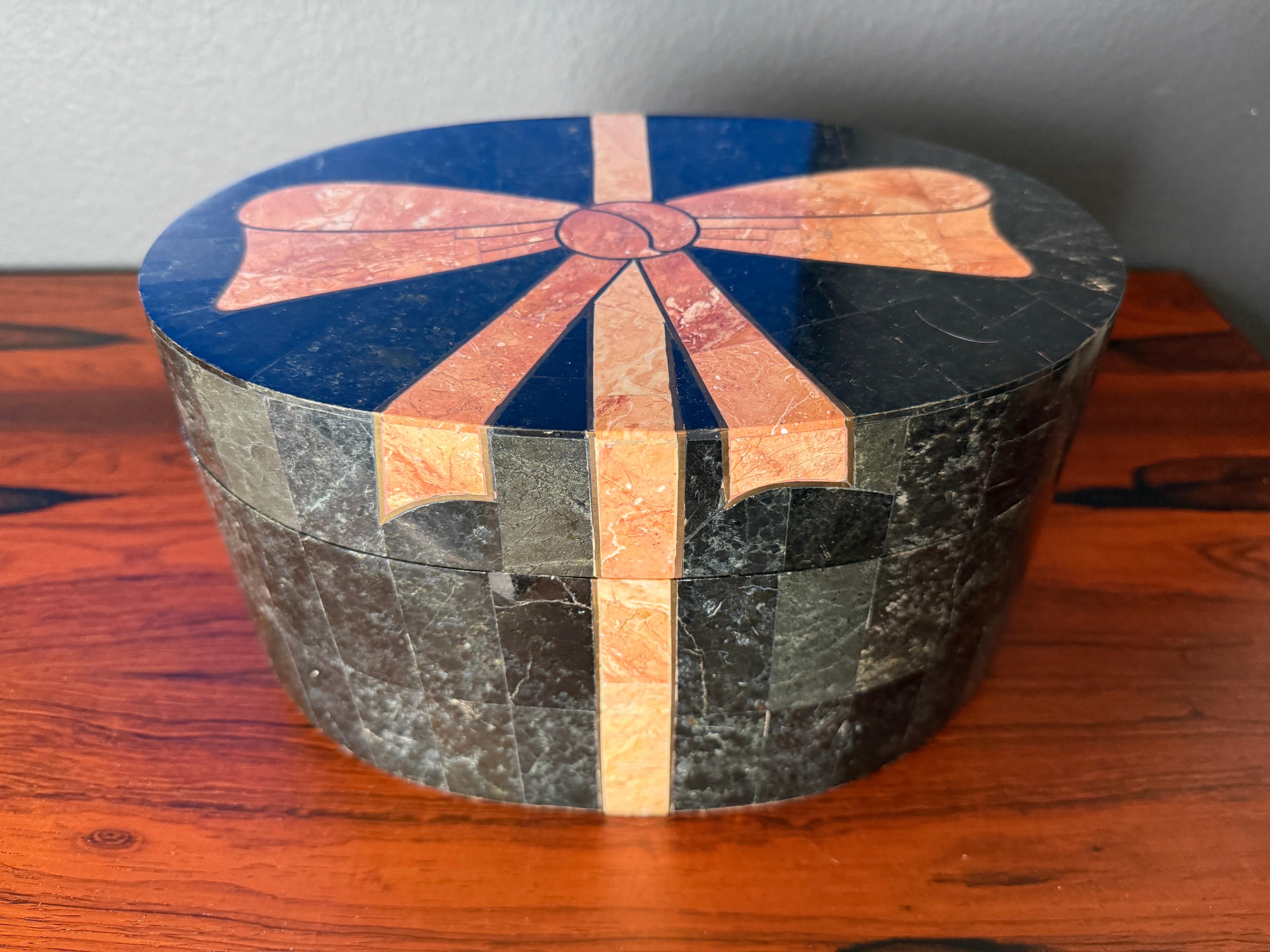 Maitland Smith attributed oval jewelry decorative box made of tessellated black and pink stone in the form of a bowtie ribbon with brass accents and velvet interior.