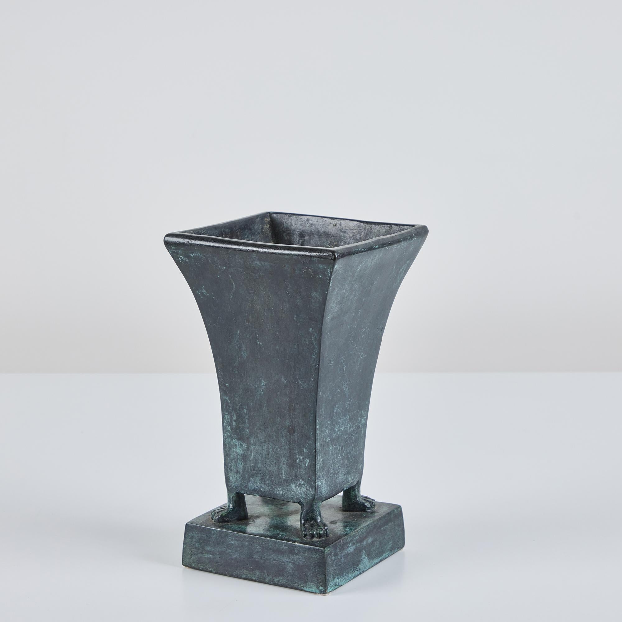 Patinated Art Deco bronze tulip vessel by Maitland-Smith. The vase features a square opening that tapers towards the bottom. The bottom of the vase is supported by four feet on a bronze pedestal. Retains the original label.

Dimensions
5.5