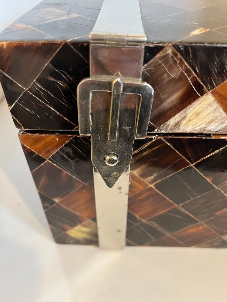 A Maitland Smith pen shell box having chrome straps with buckles.