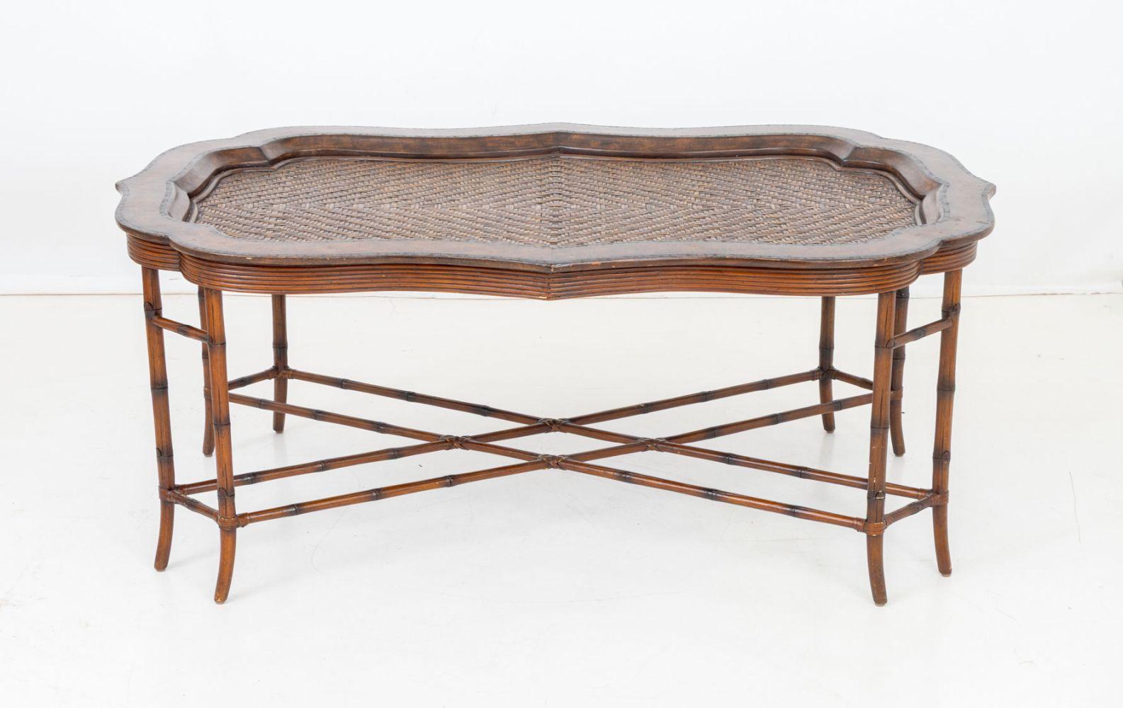 Table basse en rotin et cuir Maitland Smith, plateau en rotin tressé encastré avec bordure en cuir estampé, sur des pieds en faux-bambou. 
22,5