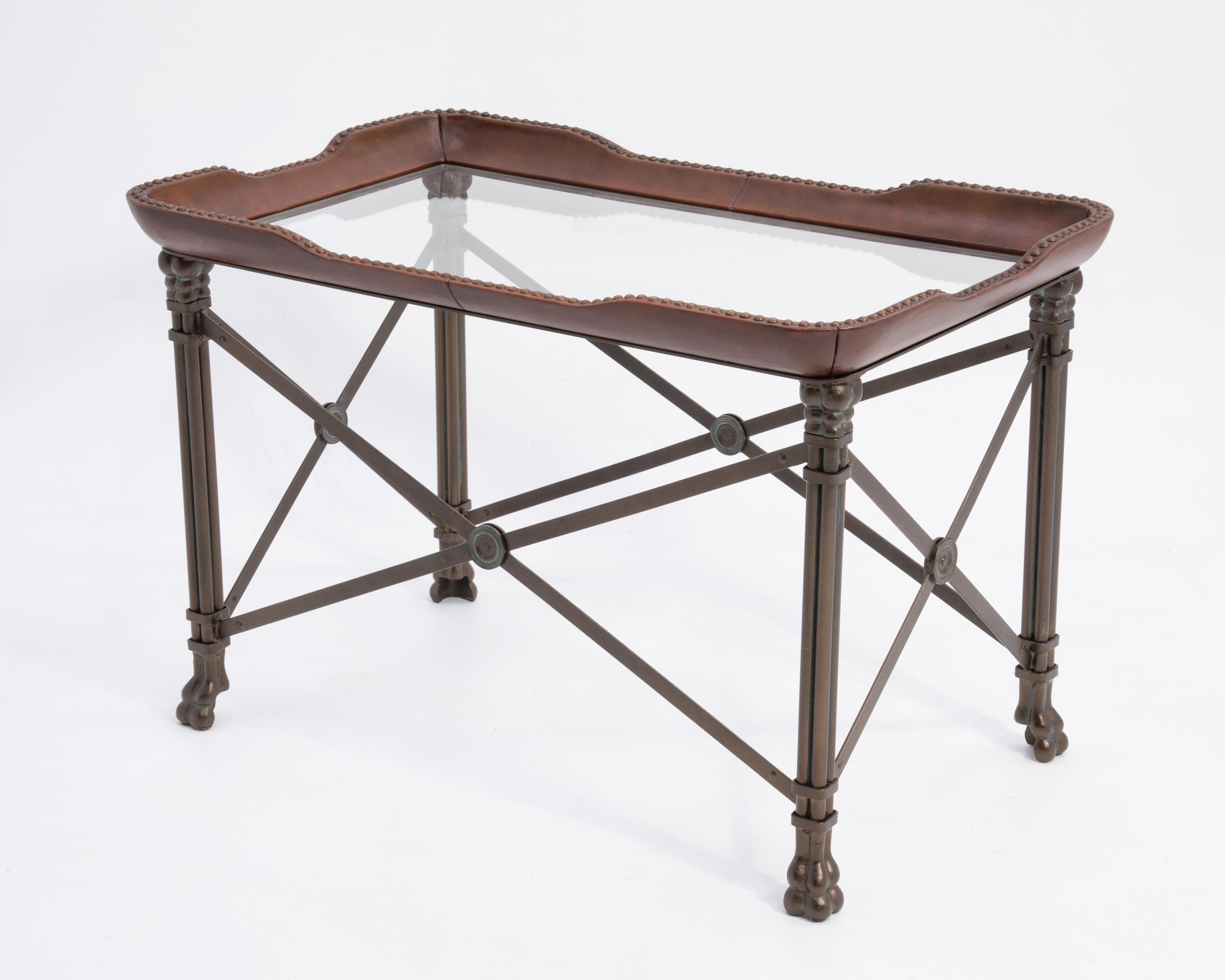 Une table vintage Maitland Smith Regency qui servira de table basse, de table d'appoint ou de table d'appoint. La table en métal bronzé avec des accents vert vert, a un plateau en cuir avec des têtes de clous antiques, un insert en verre et des