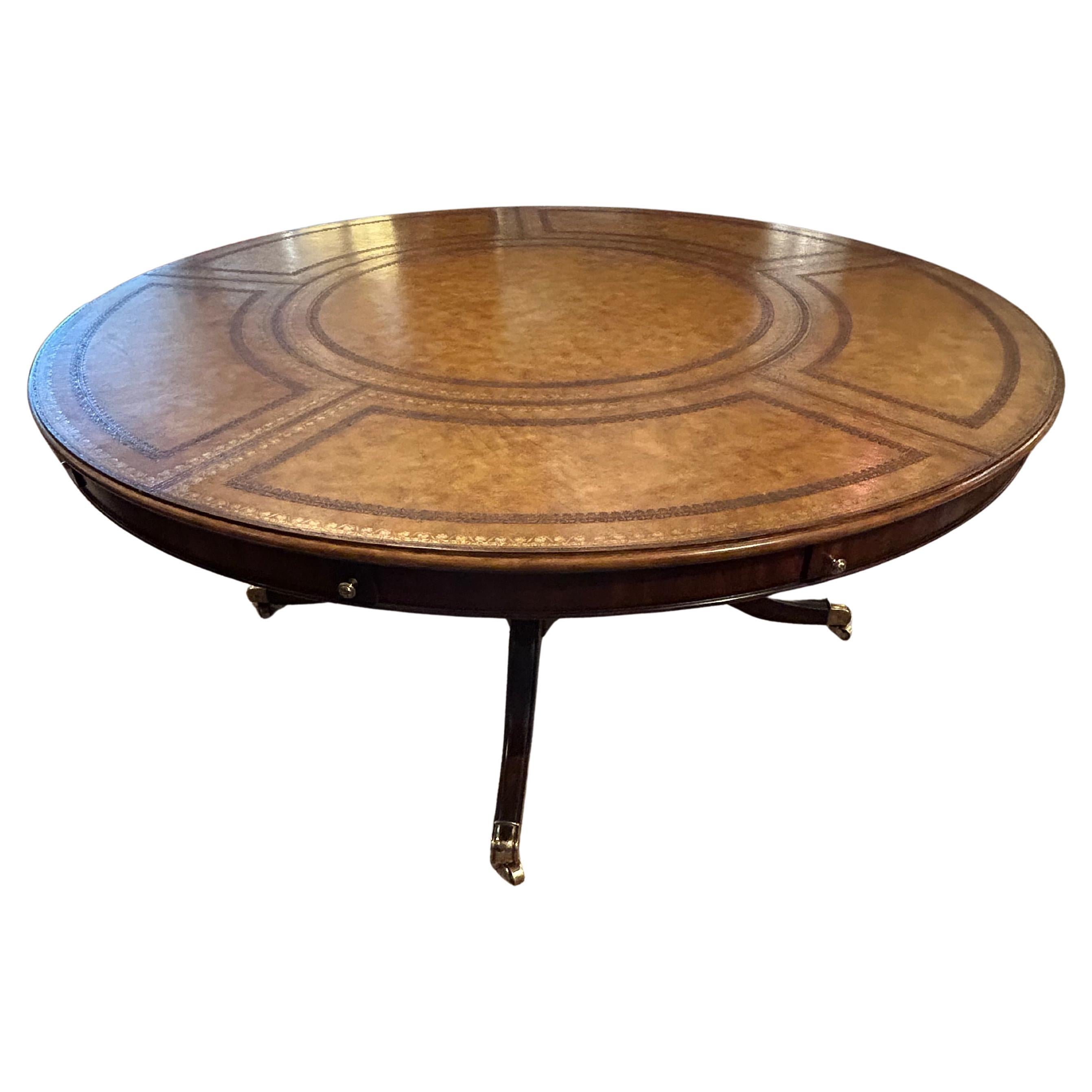 Impressive and beautifully crafted round extension table having 5 leaves that insert around the periphery of the table.  Pedestal base has four turned columns and handsome cabriole legs. Surface is a gorgeous golden brown tooled leather, embossed