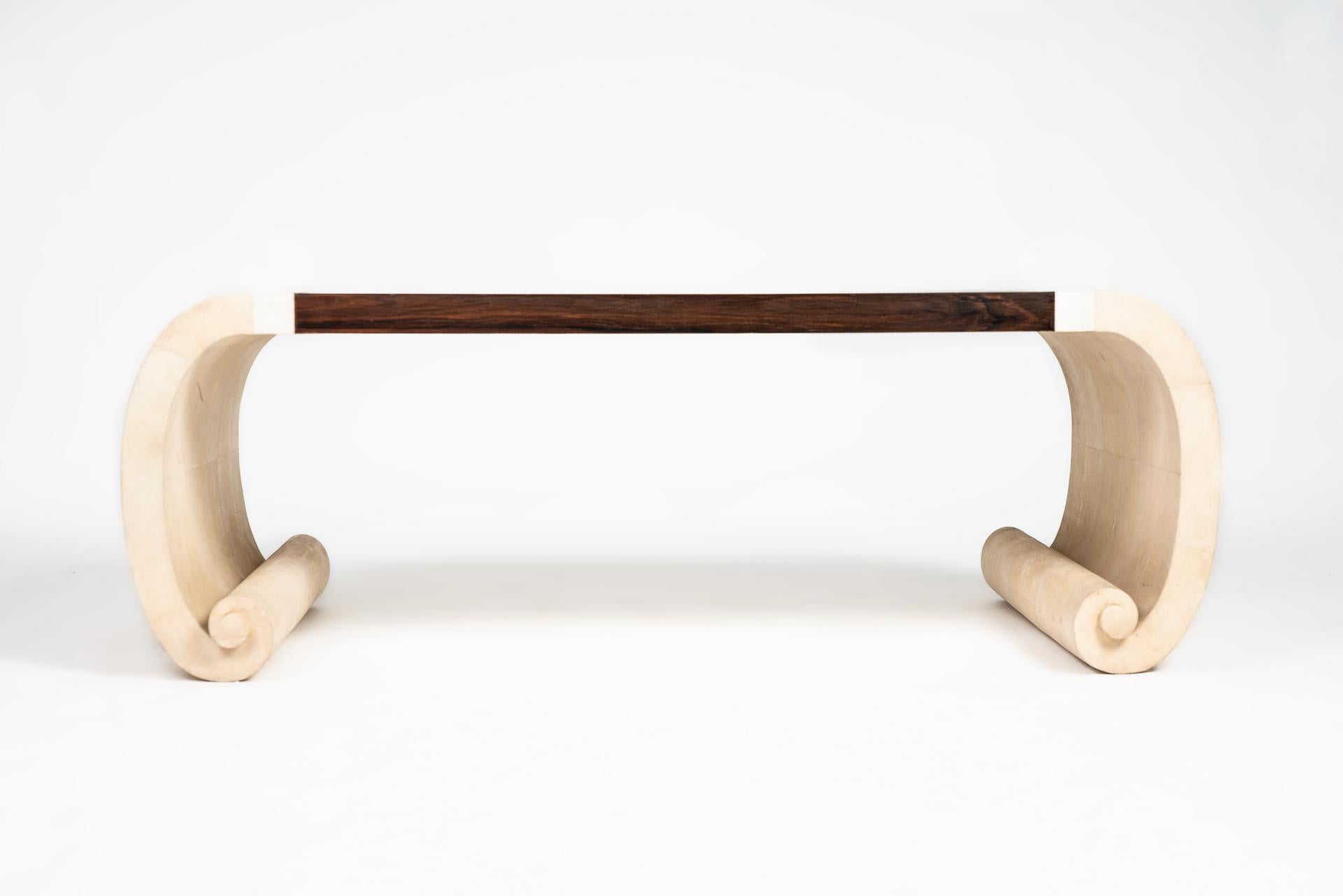 Cette belle table basse manufacturée par Maitland Smith montre le travail délicat avec des matériaux comme la pierre de corail, le galuchat et l'ébène. La structure incurvée des pieds est recouverte de galuchat, sur les côtés et au centre il y a des