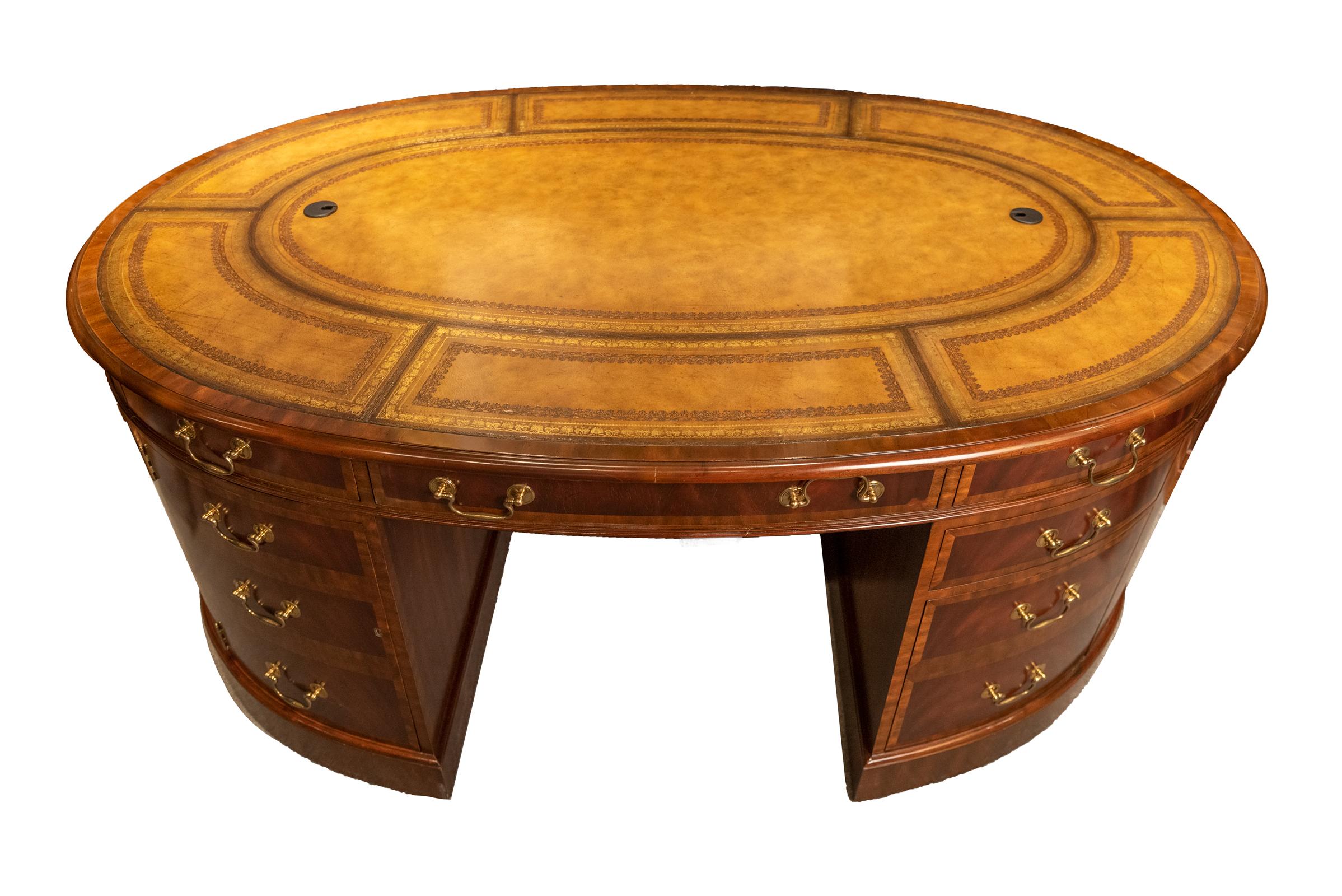 Fine oval leather-top partners desk. With a leather inset top and walnut and flame mahogany veneers, this desk is made in three pieces: two pedestals and a top. Drawers and files on both sides of this desk make it a true partners desk: four small