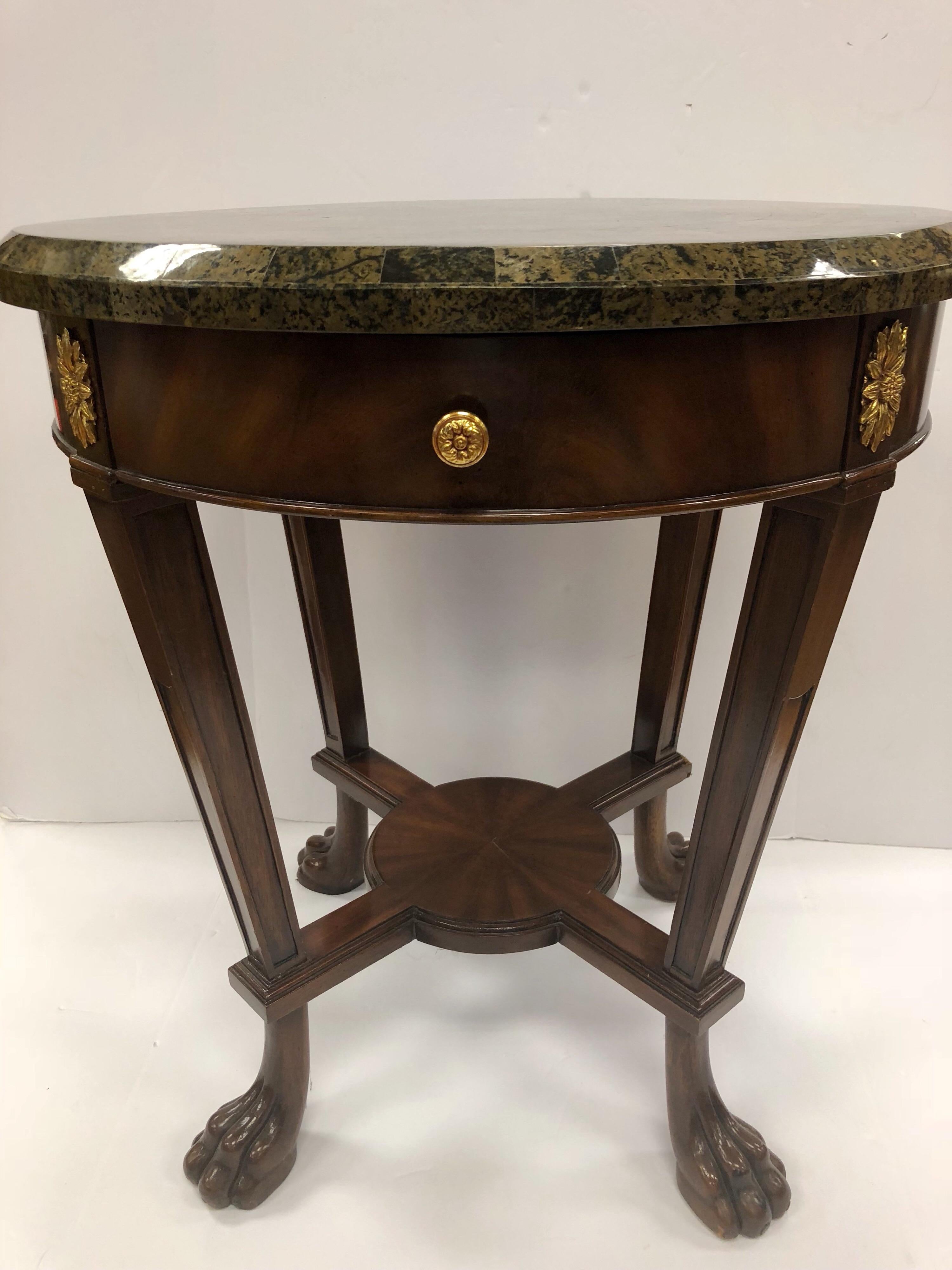 Signed mahogany and marble Maitland Smith round side/occasional table with top drawer for storage.
Marble is a olive and black color scheme and is accentuated by brass at sides.