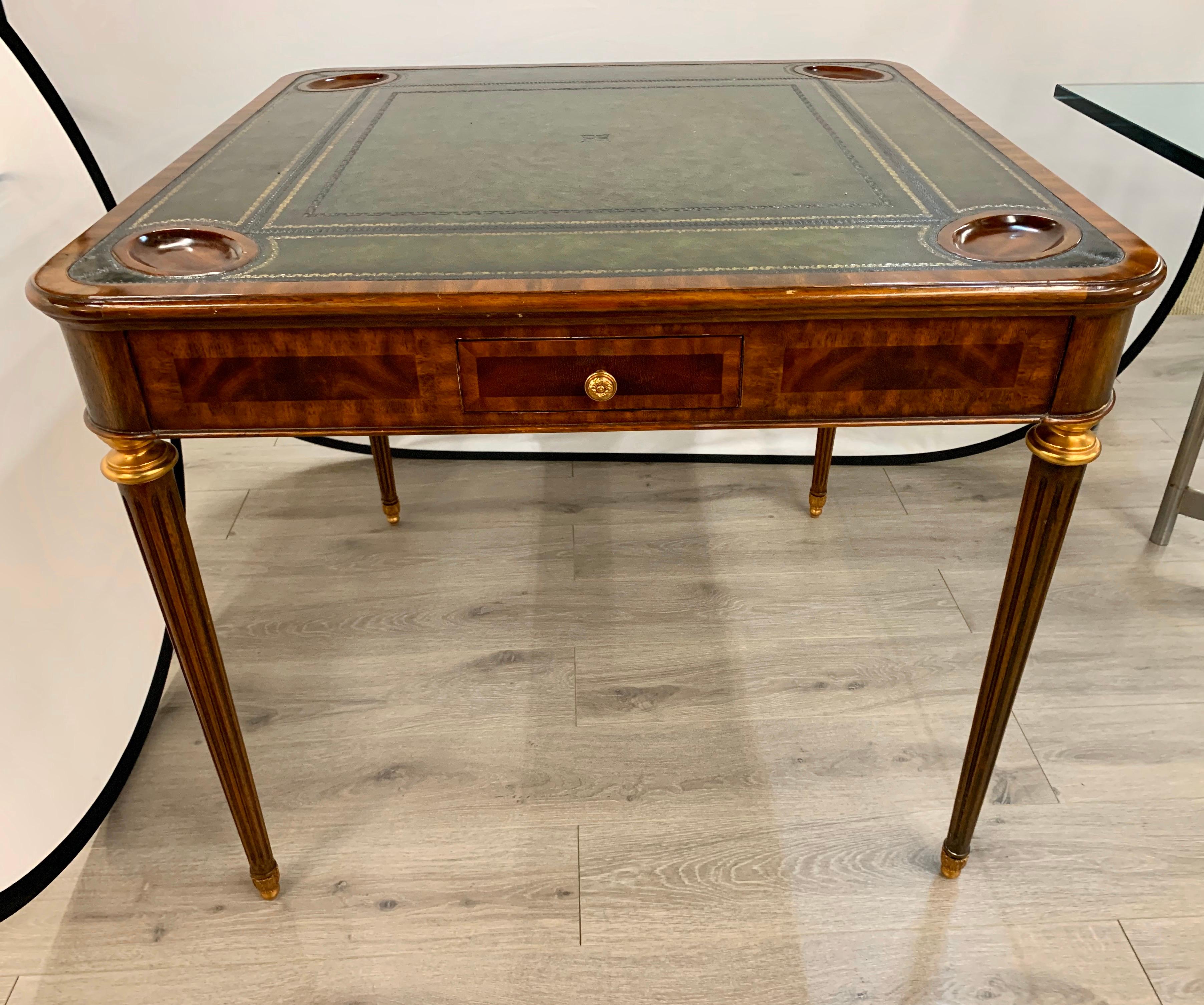 Elegant signed Maitland Smith mahogany game table with green leather top with gold gilt detail. 
Wonderful curved lines with round cup holders at each corner.
Note detail of craftsmanship in the woodwork. Perfect for an office, master bedroom,