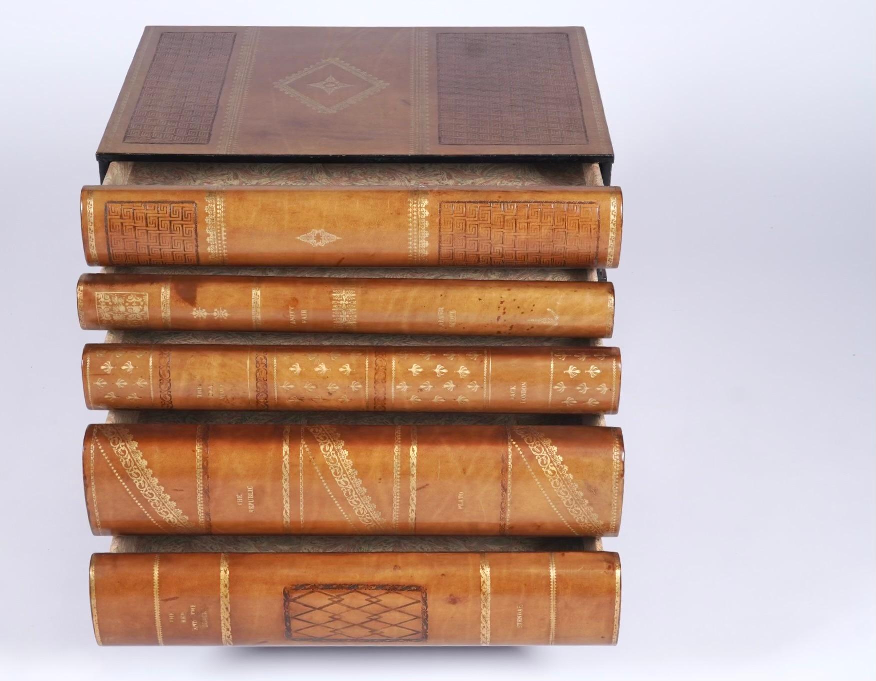Maitland - Smith stacked leather bond books chest of drawers / end or side table resting on a Philippine mahogany base and legs. The table is created to look like a stack of leather bond books resting on a wooden base, the case good has 5 drawers