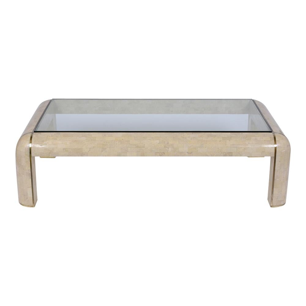 An extraordinary vintage Maitland Smith coffee table crafted in solid wood covered in a beautiful ivory color stone tile veneer with a brass intricated flat brass molding details and has been fully restored by our team of craftsmen. This table comes