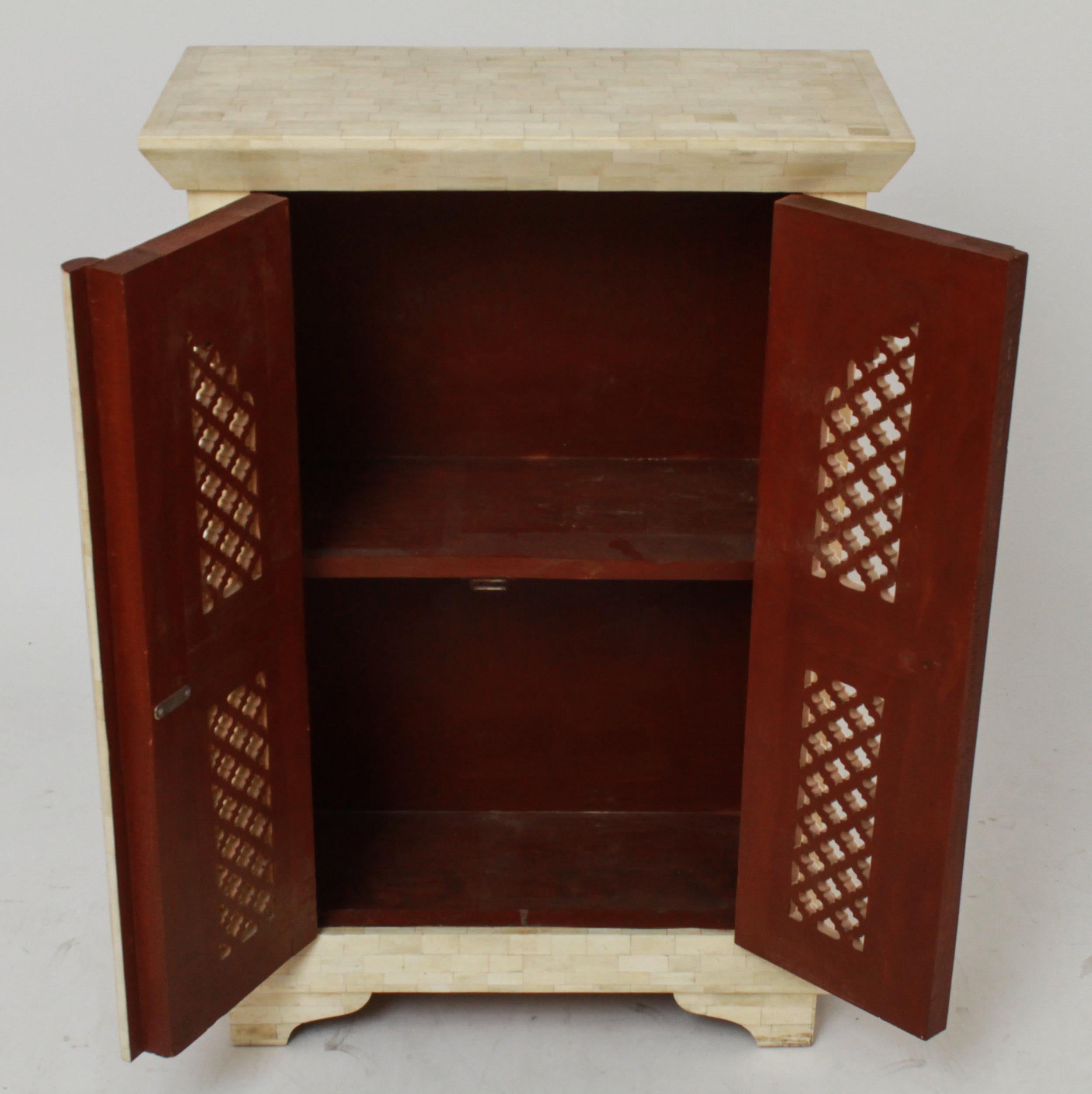 Modern Maitland Smith style tessellated side table cabinet with shaped top and two doors. The piece is featuring stylized arches and a decorative lattice motif. In great vintage condition with age-appropriate wear and use.