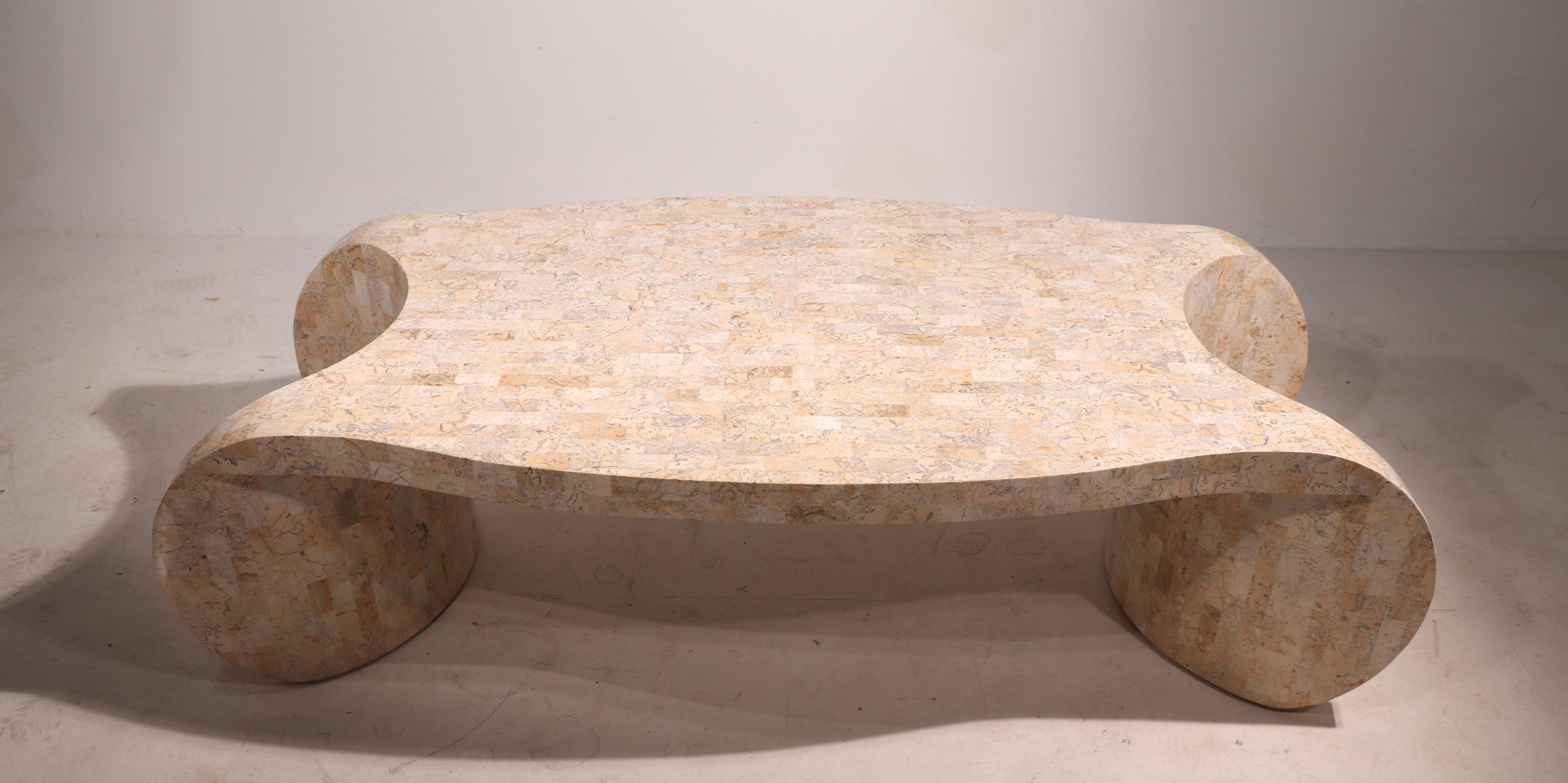 Stylish complex curved coffee table of tessellated stone by Maitland Smith. This example is in very fine original condition, free of damage or repairs.