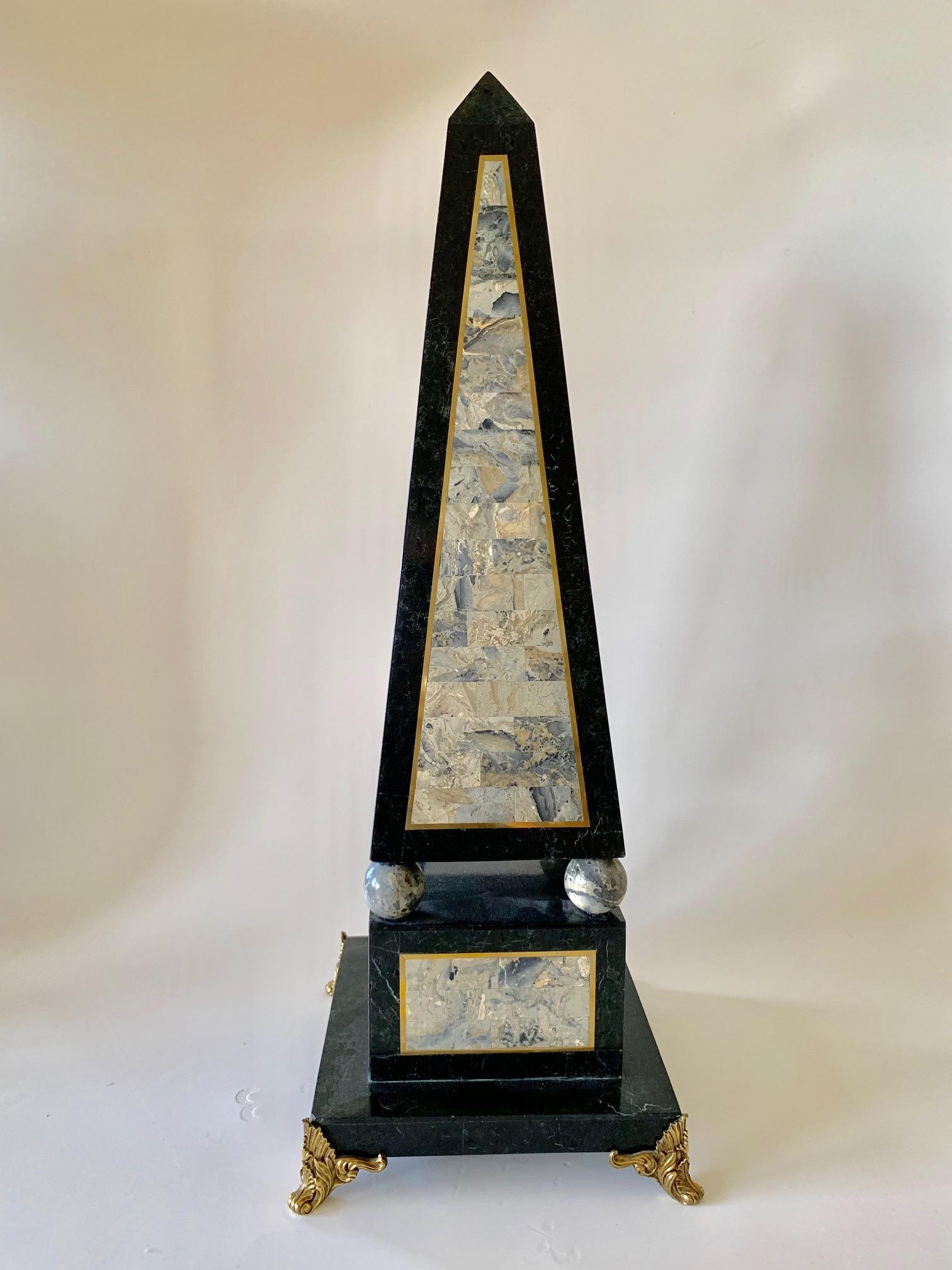Decorative Maitland Smith tessellated black marble obelisk circa the 1980s, comprised of a mixture of tessellated colored marble. The decorative center features hues of greys which are outlined in gold emphasizing the architectural geometric pattern